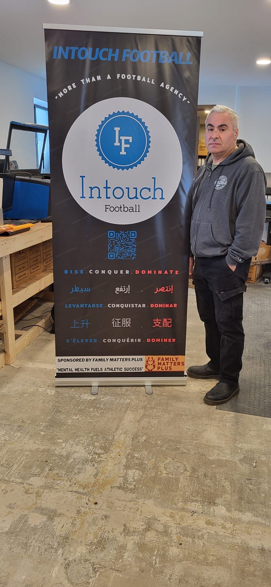 A man stands next to a banner that reads