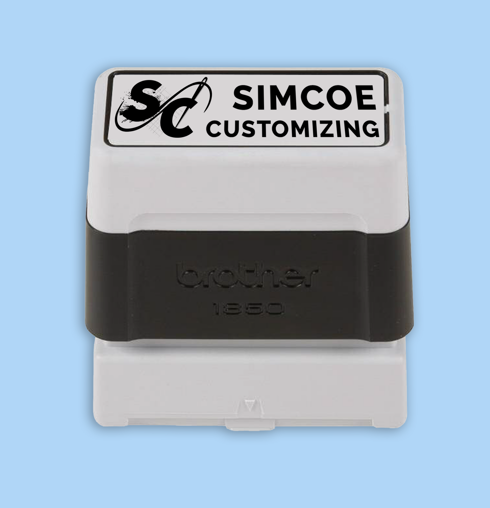 Self-inking stamp, white and black, reads 