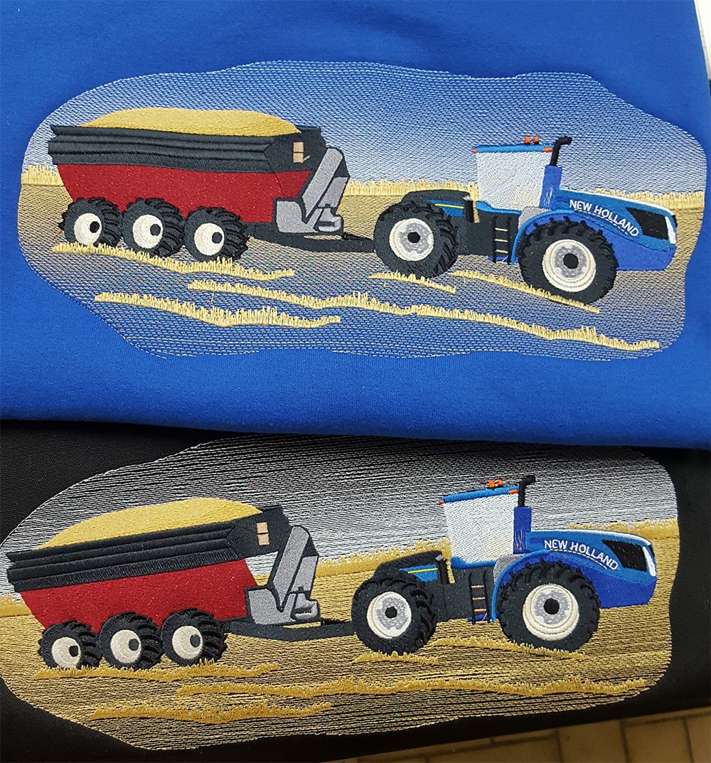 Blue and black shirts with embroidered tractors pulling grain carts in a field.