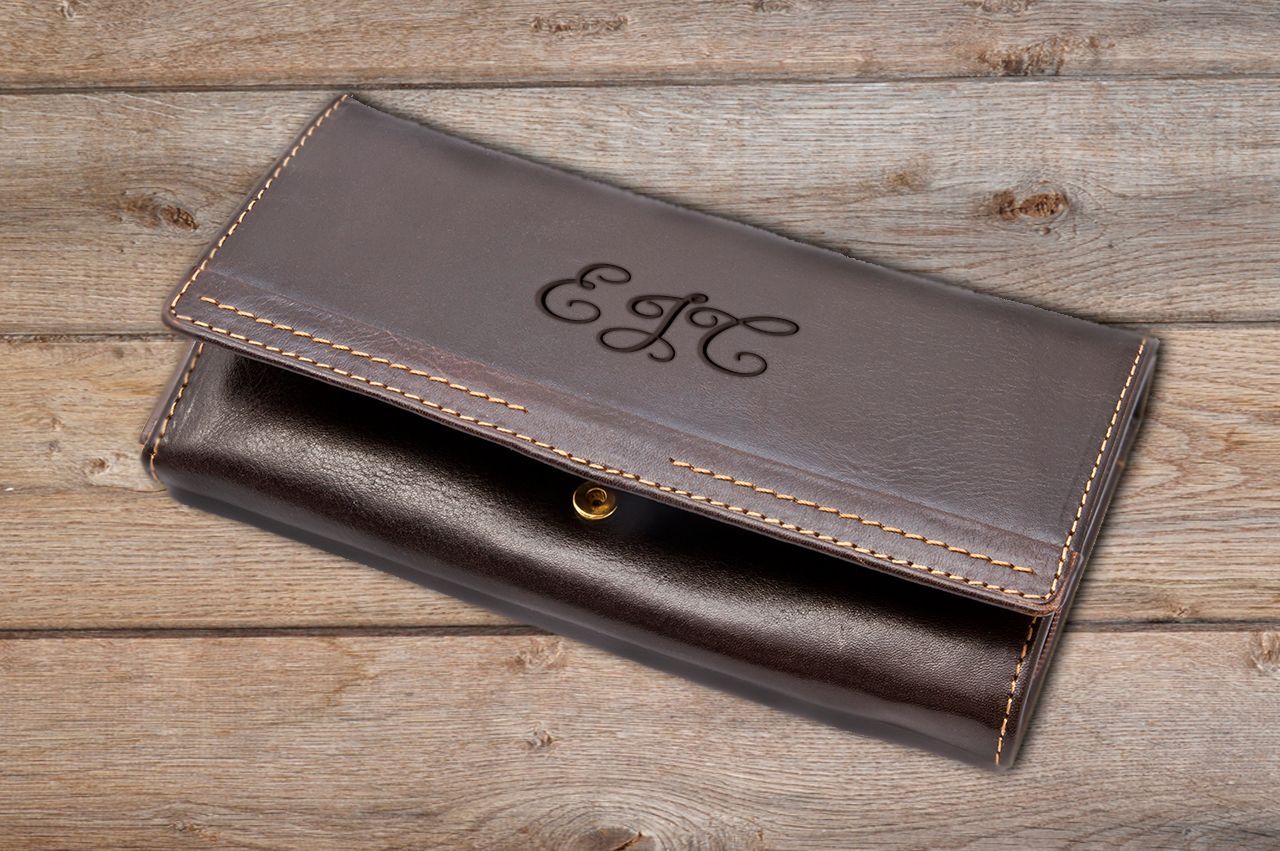 Brown leather wallet with stitched edges and gold button, monogrammed with