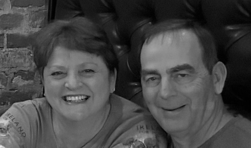 A black and white photo of a man and a woman smiling for the camera.