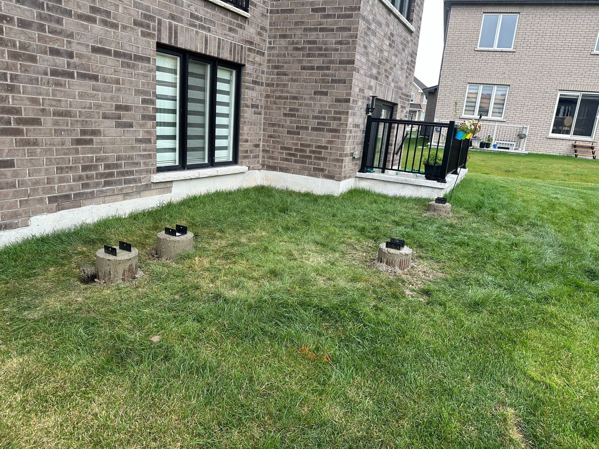 A brick house with a lush green lawn in front of it.