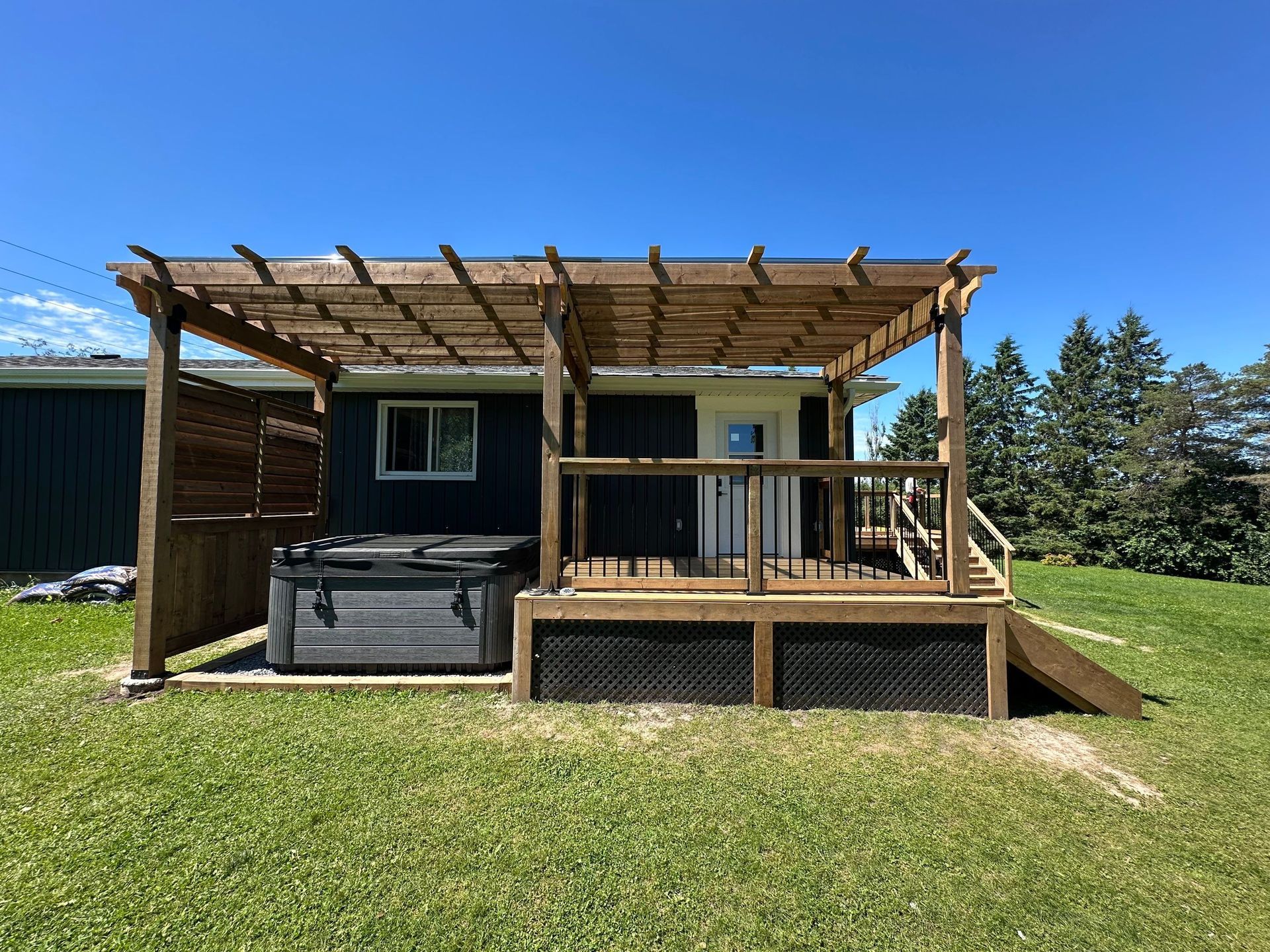 A house with a pergola and a hot tub on the deck.