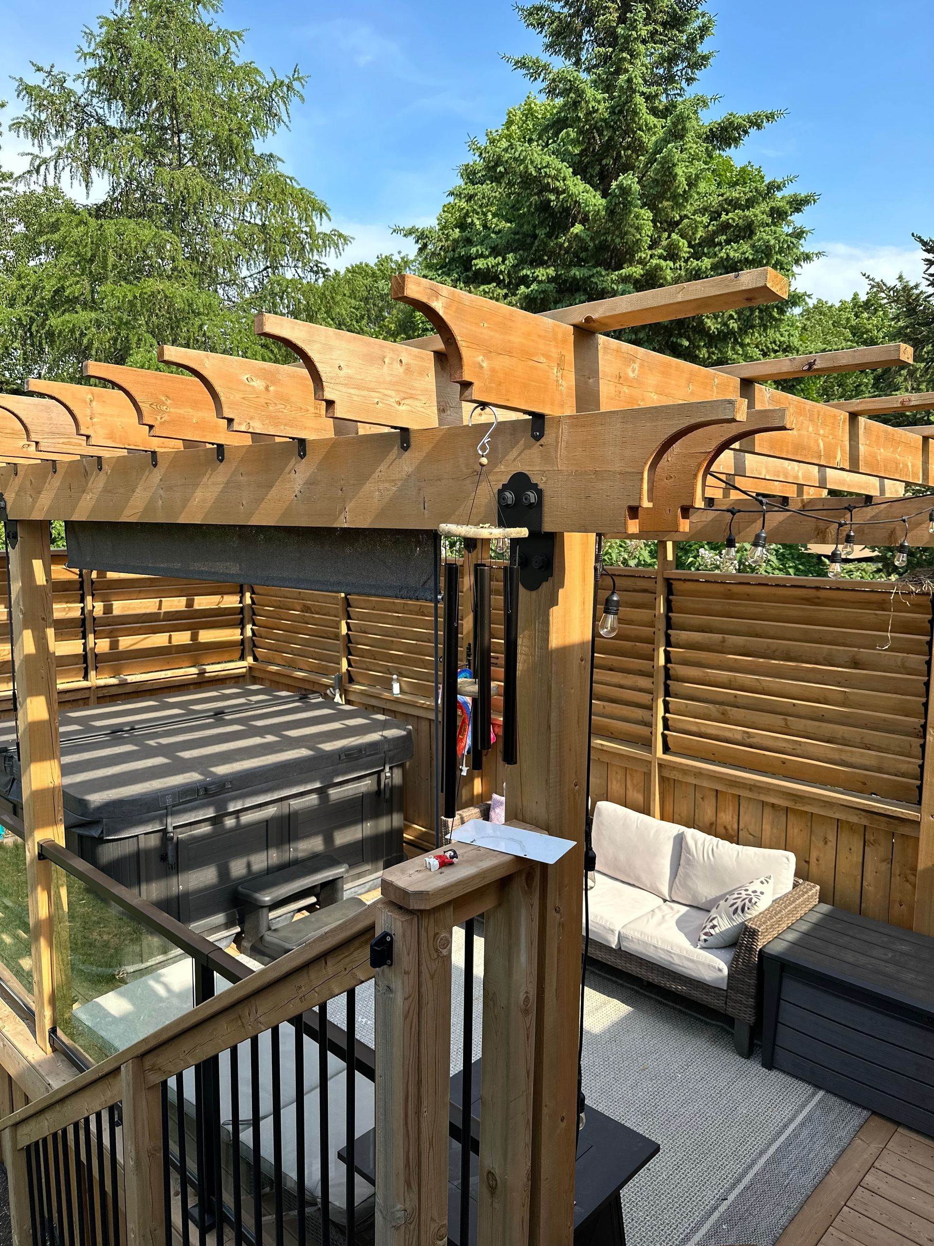 A wooden pergola is sitting on top of a wooden deck.