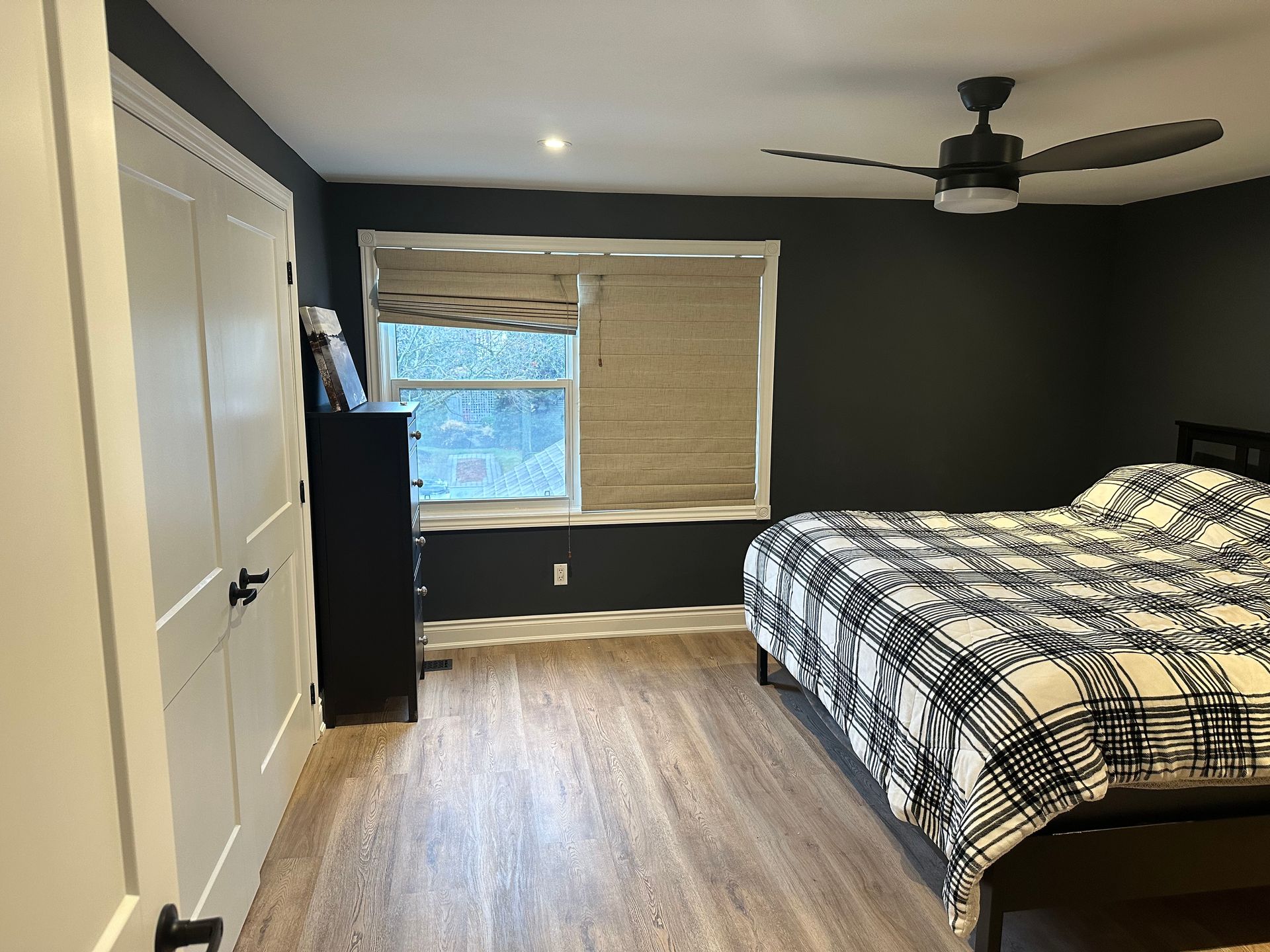 A bedroom with a bed and a ceiling fan