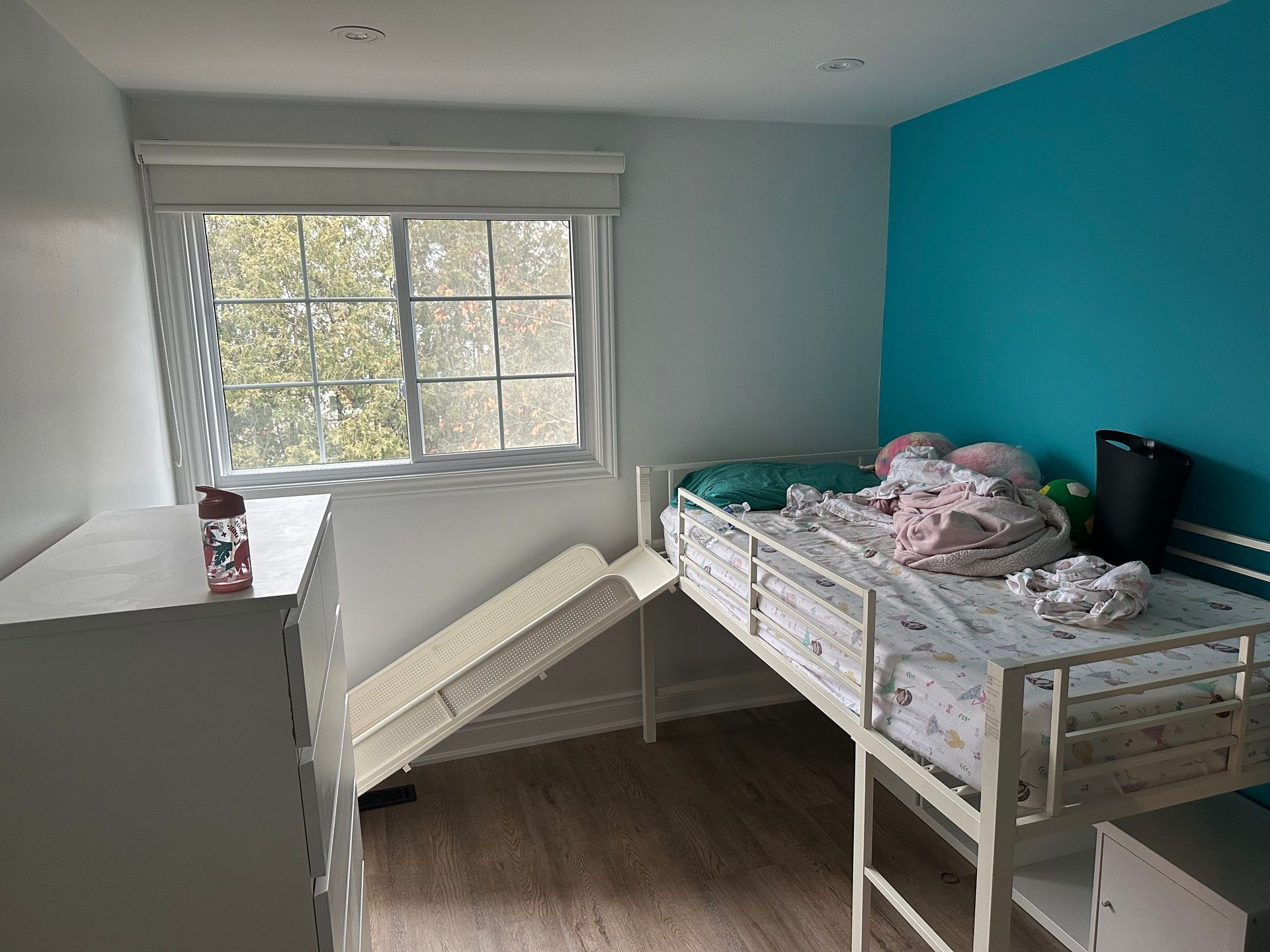 A bedroom with a bunk bed and a window.