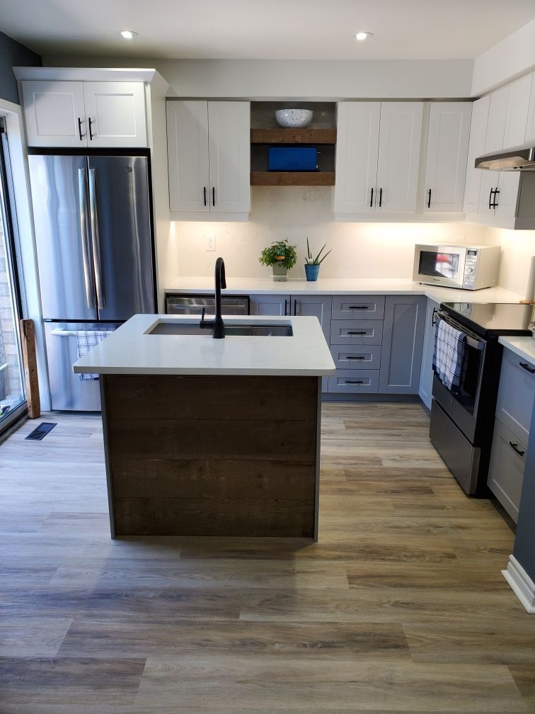 A kitchen with stainless steel appliances and a large island in the middle.