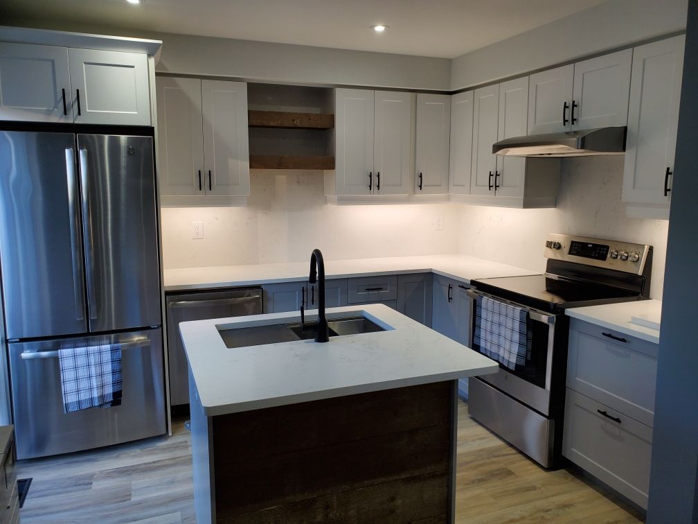 A kitchen with stainless steel appliances and white cabinets