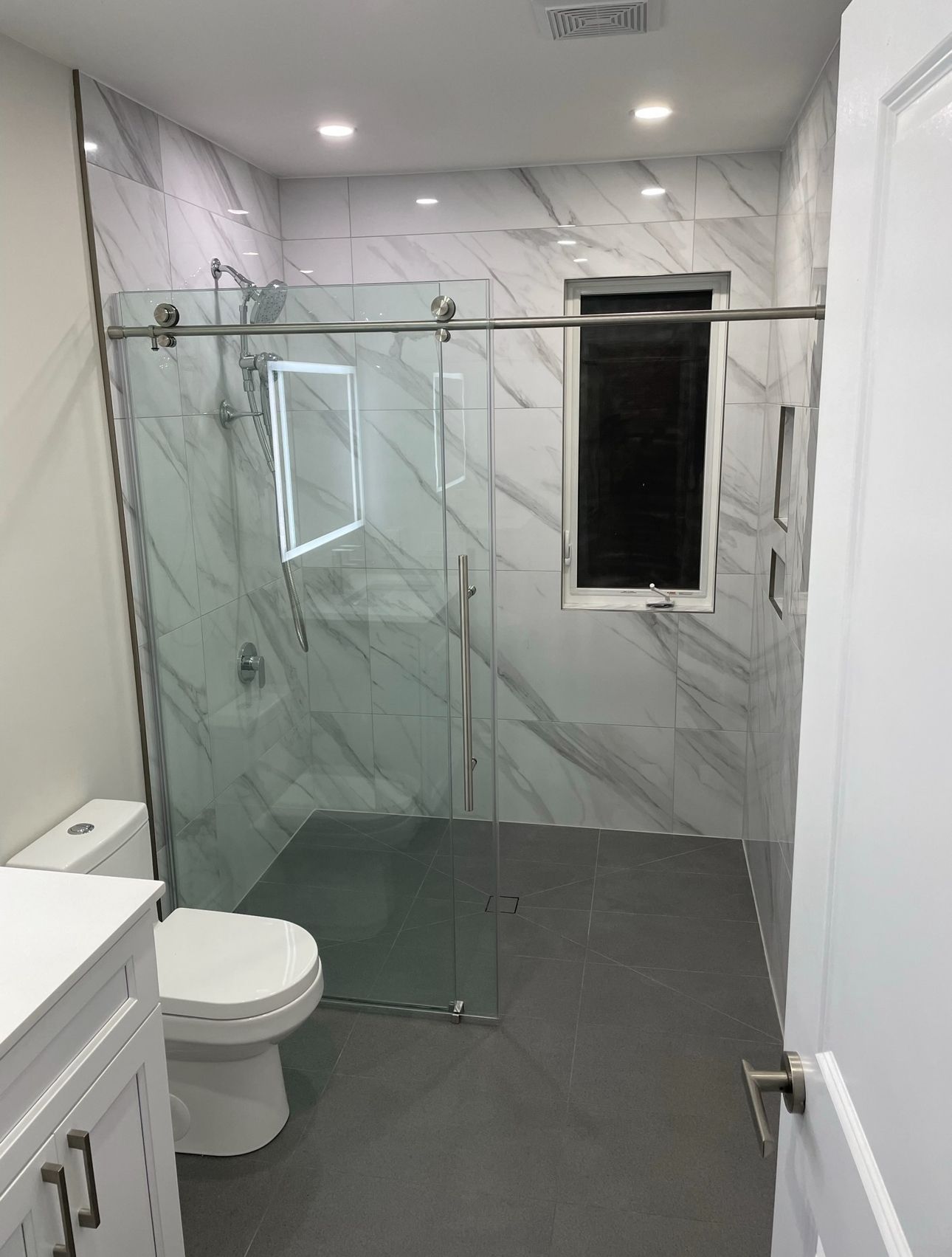 A bathroom with a toilet , sink , and walk in shower.