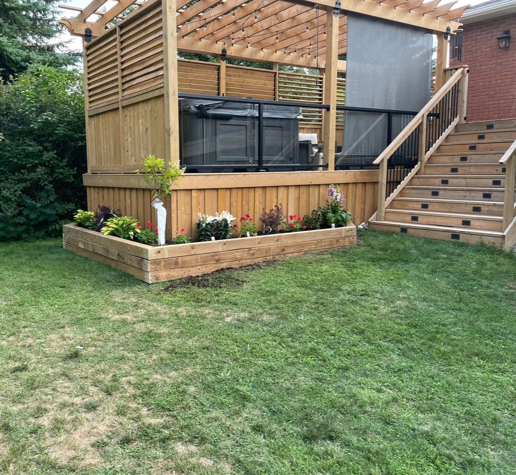 A wooden deck with a pergola and stairs in a backyard.