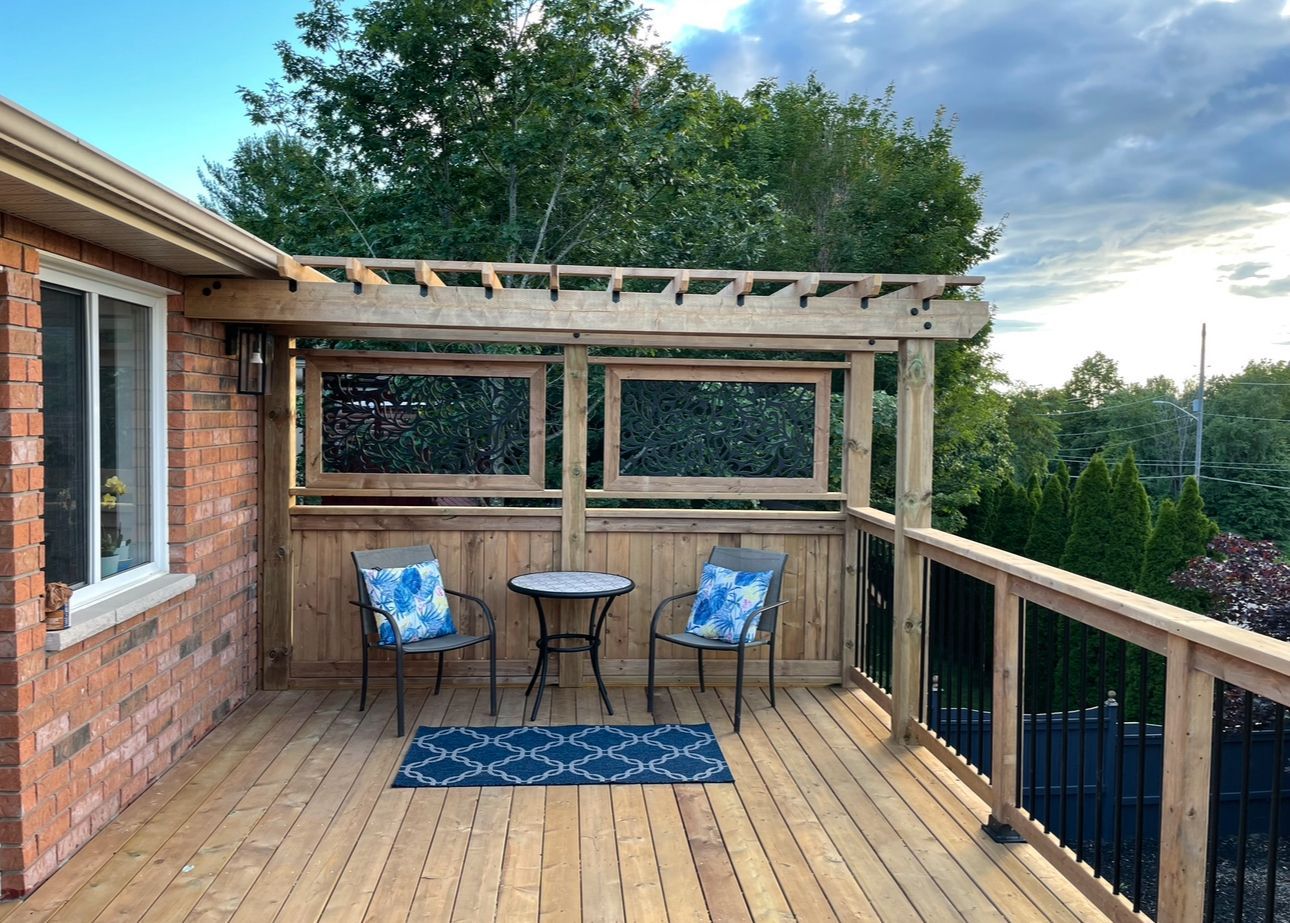 There is a wooden deck with a table and chairs on it.