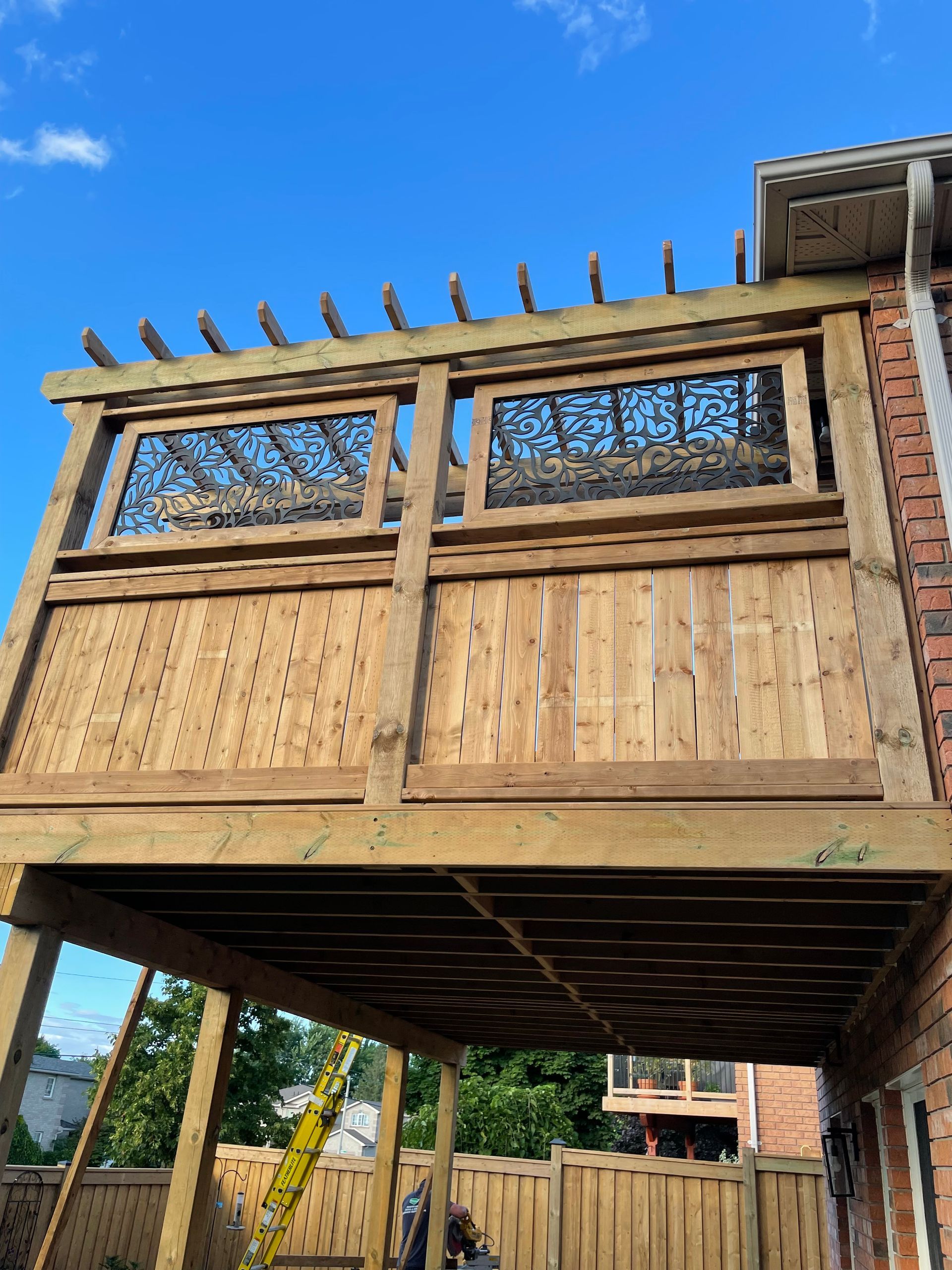 A wooden deck is being built on top of a brick house.