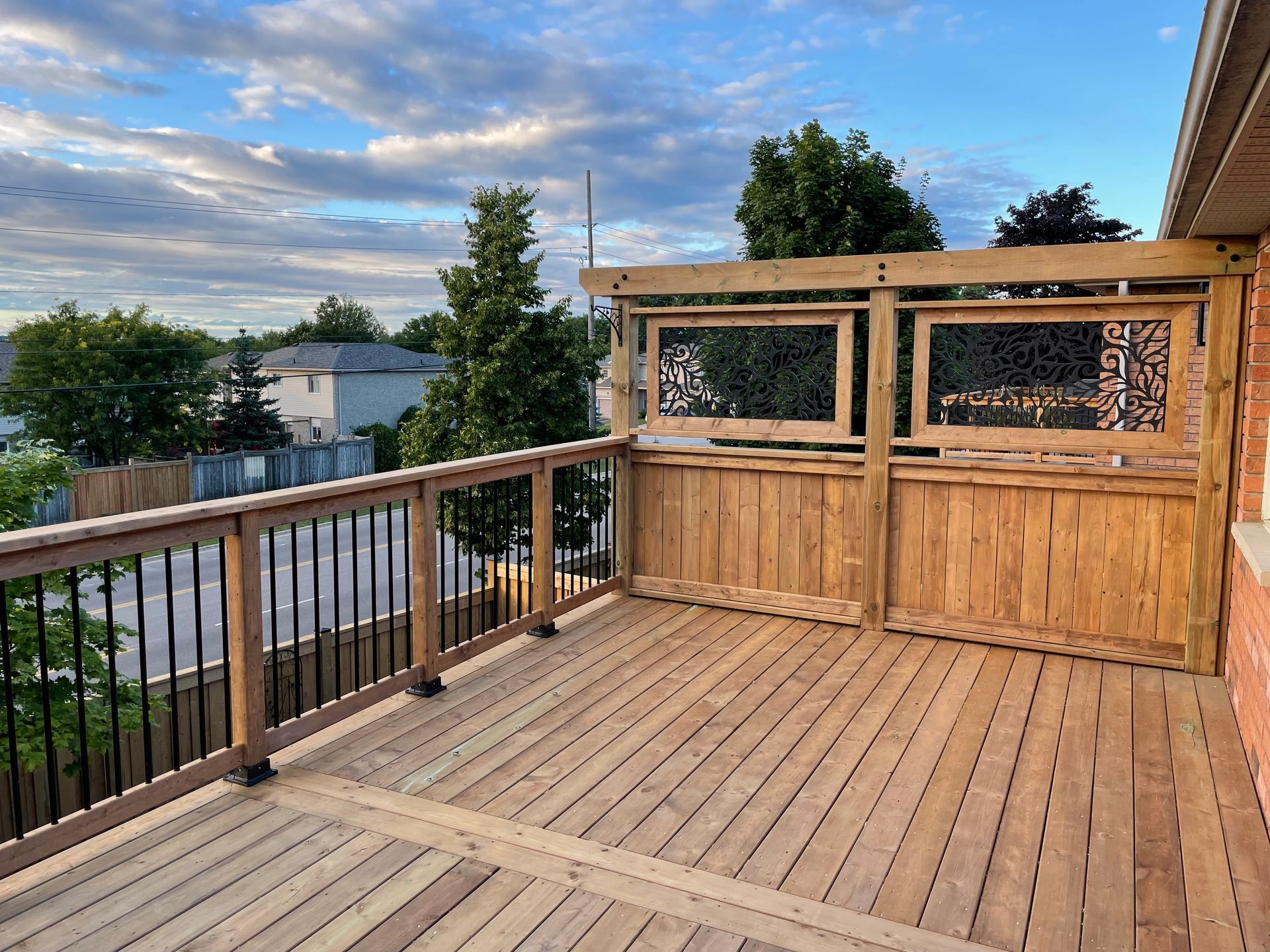 A wooden deck with a railing and a window.