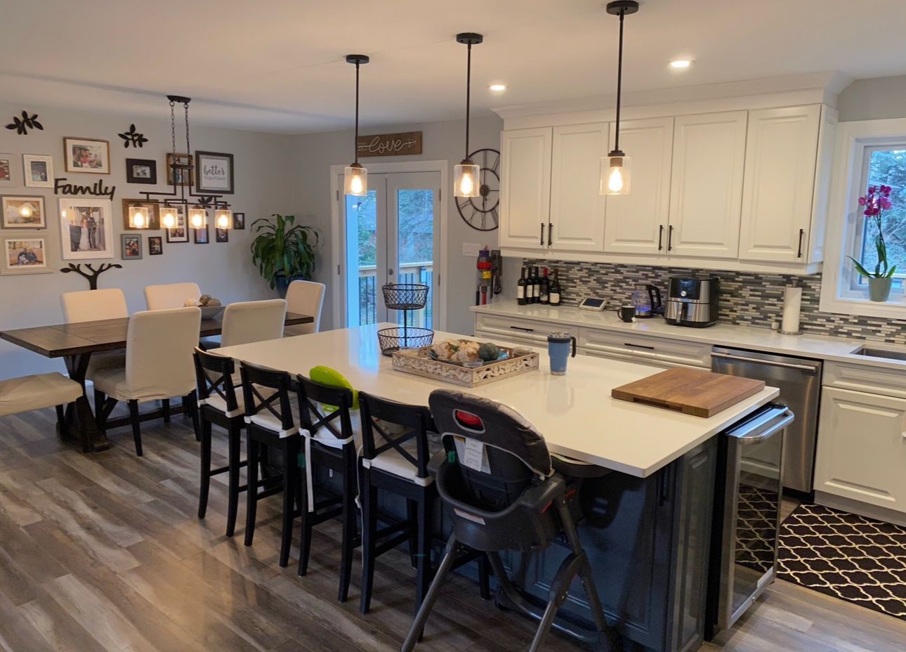 A kitchen with a large island and a dining table and chairs.