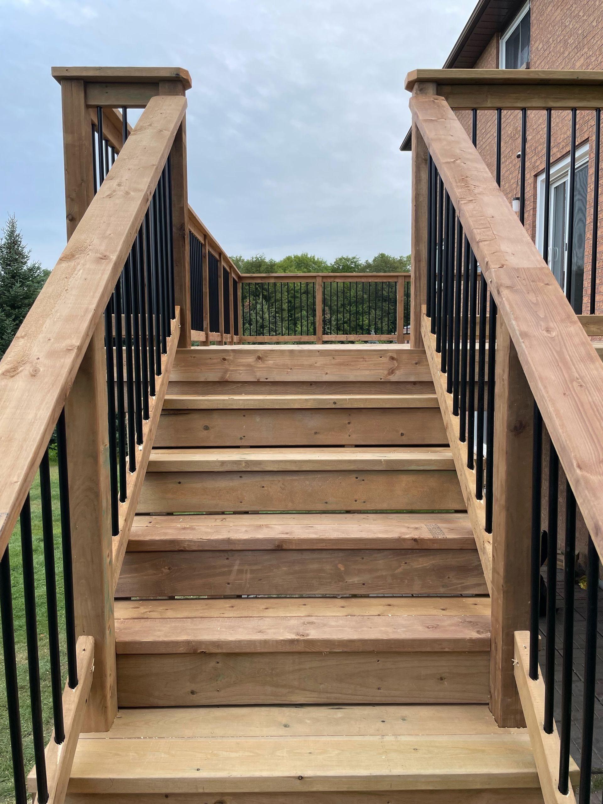 A wooden deck with stairs and a metal railing