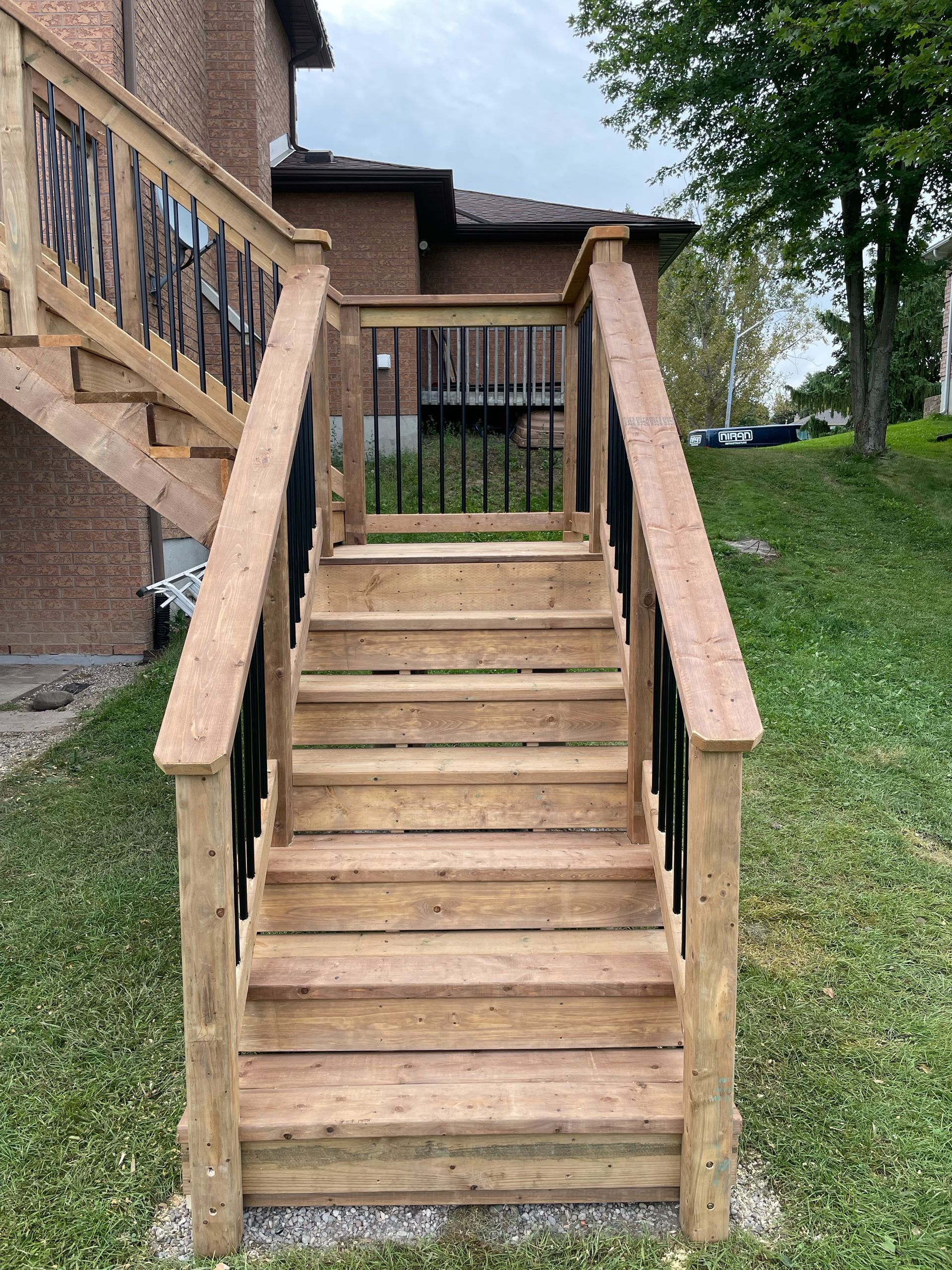 A wooden deck with stairs leading up to a house.