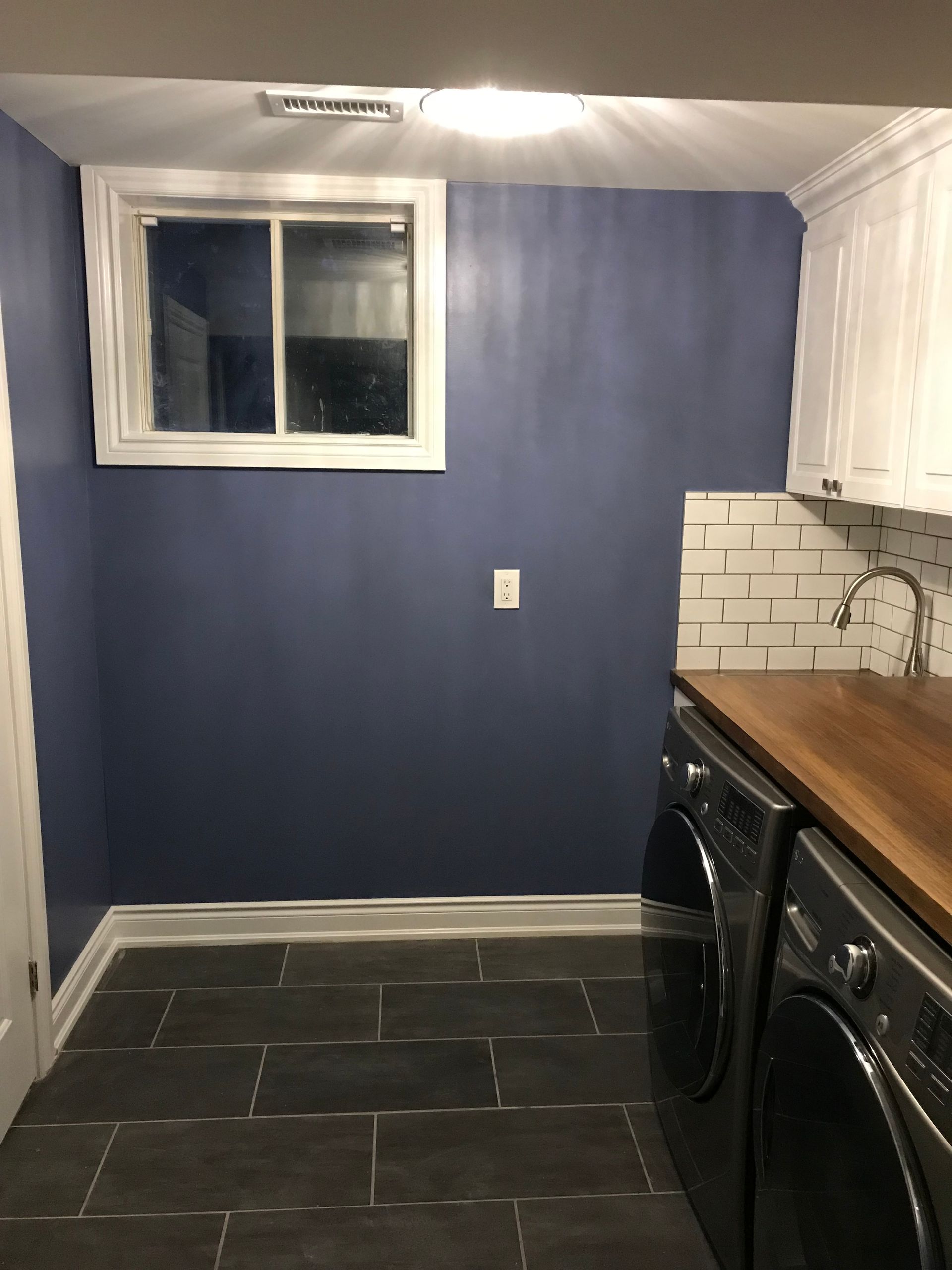 A laundry room with a washer and dryer and a window
