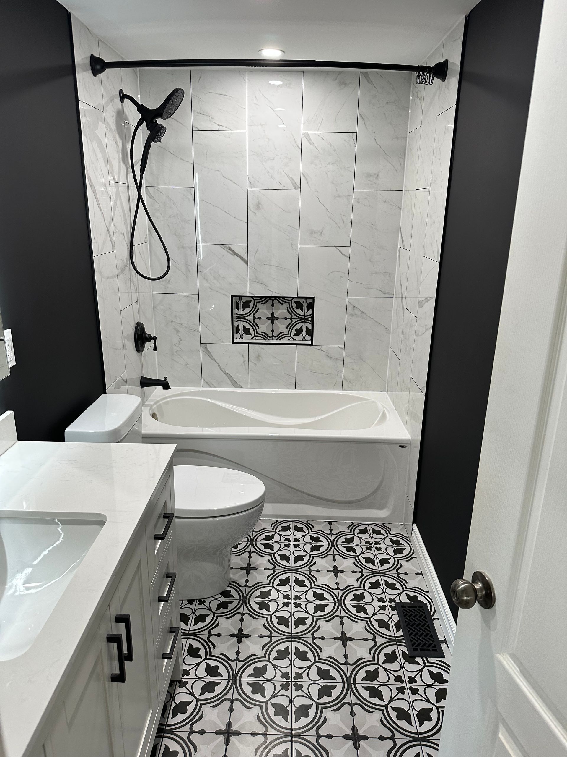 A bathroom with a bathtub , toilet , sink and shower.