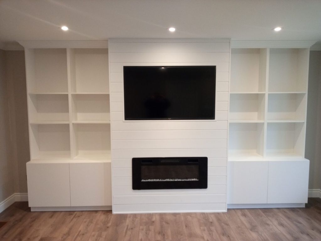A living room with a fireplace and a flat screen tv
