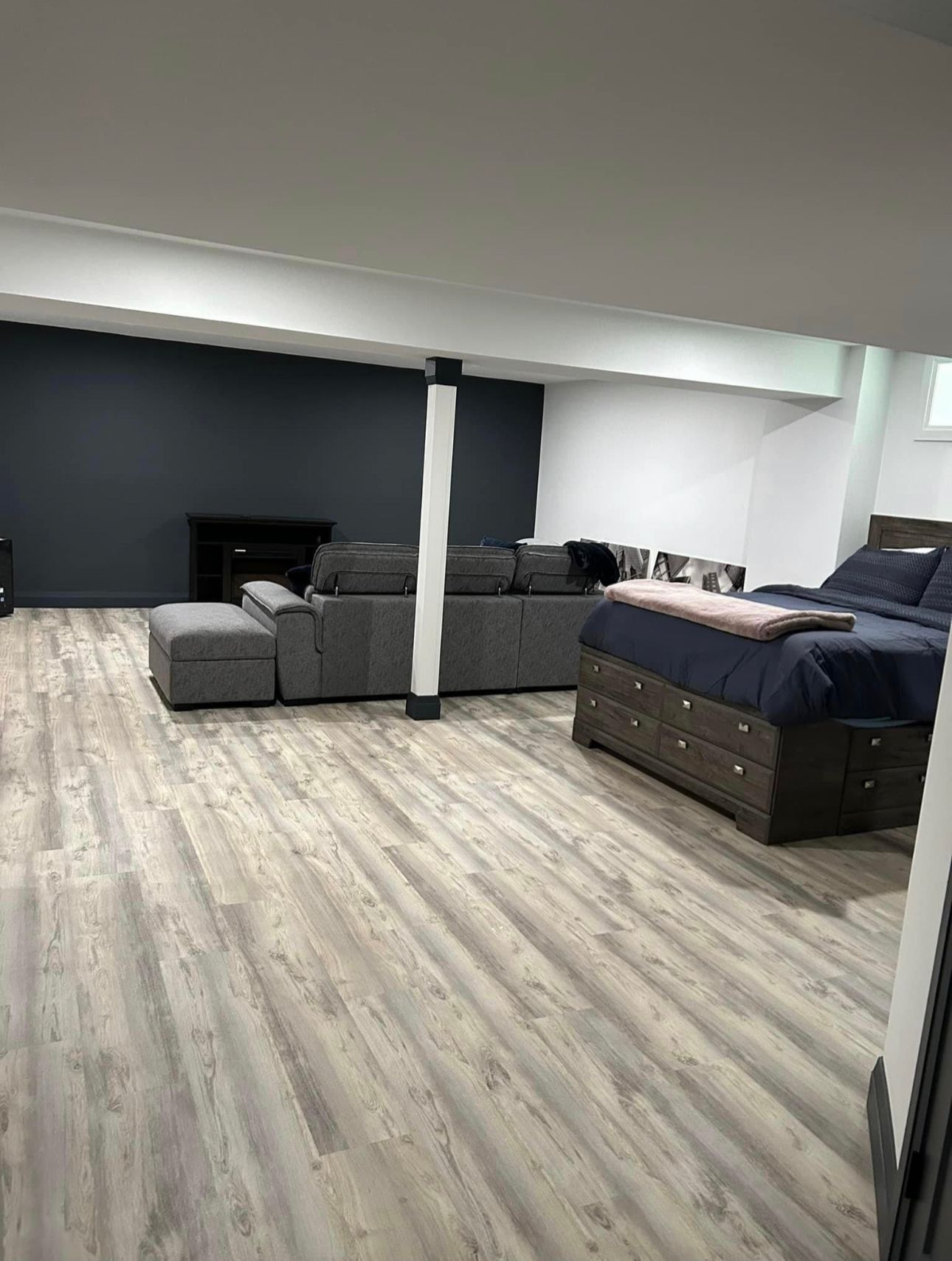 A living room with a couch , bed and fireplace.