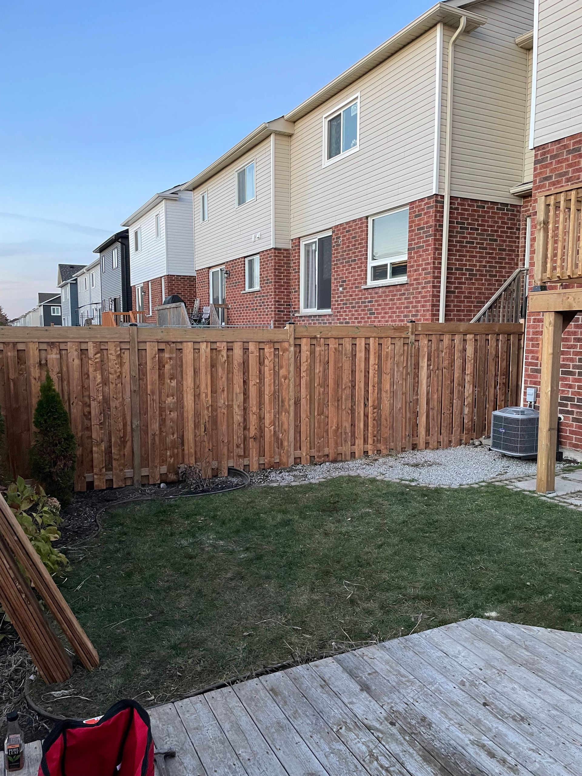 A wooden fence is being built in the backyard of a house.