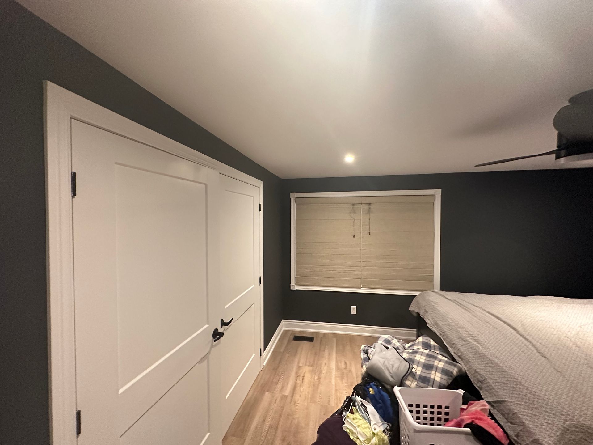 A bedroom with a bed , a window and a ceiling fan.