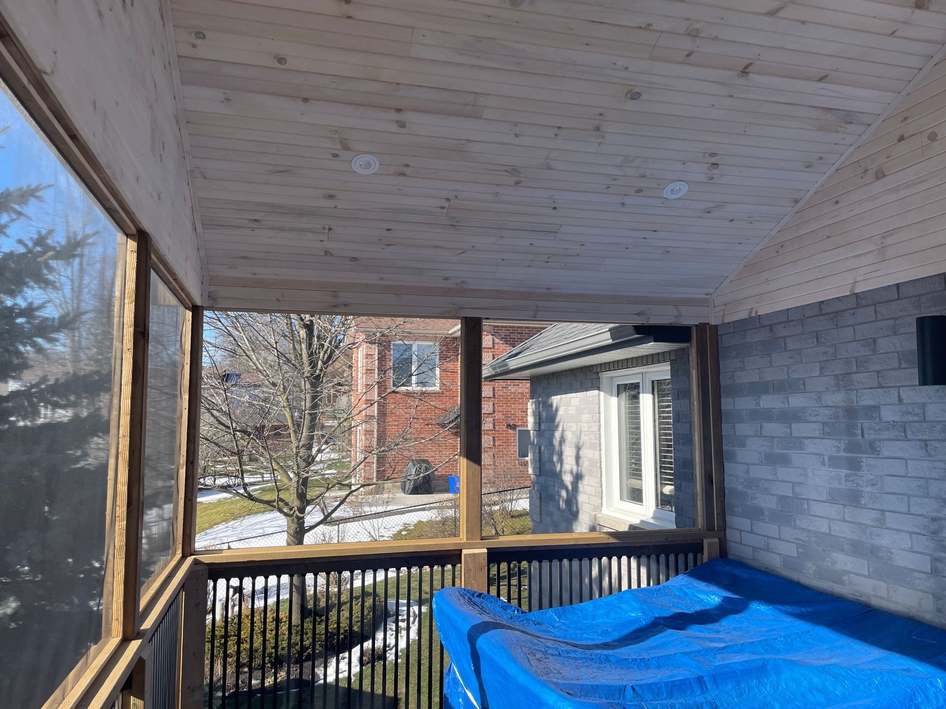 A screened in porch with a hot tub in it