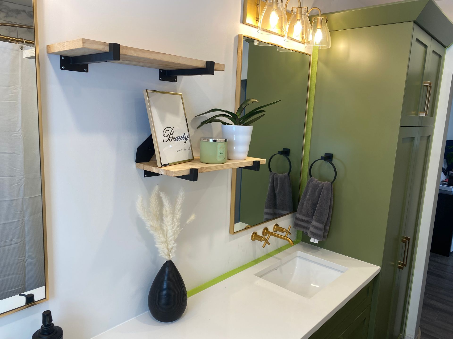 A bathroom with a sink , mirror , and shelves.