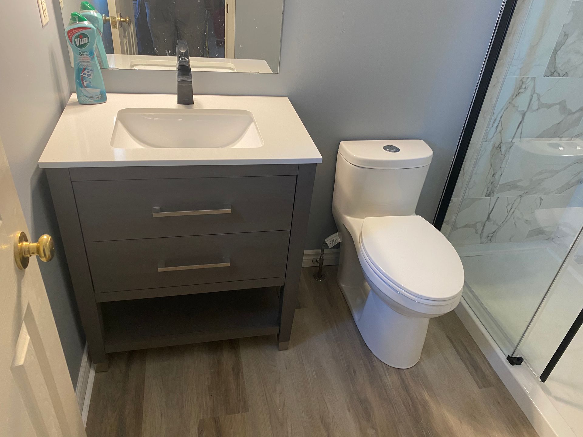 A bathroom with a sink , toilet and shower.