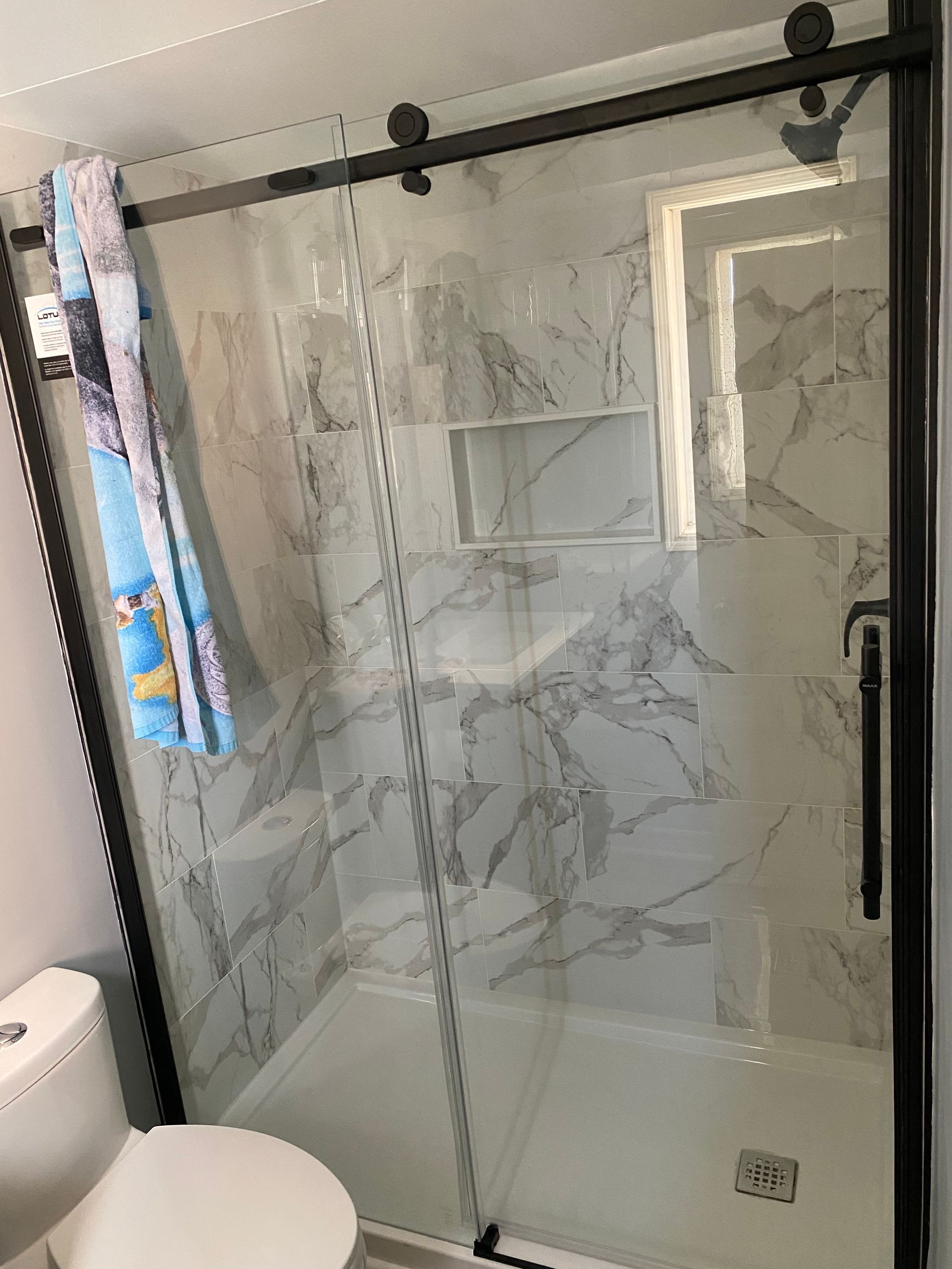 A bathroom with a sliding glass shower door and a toilet.