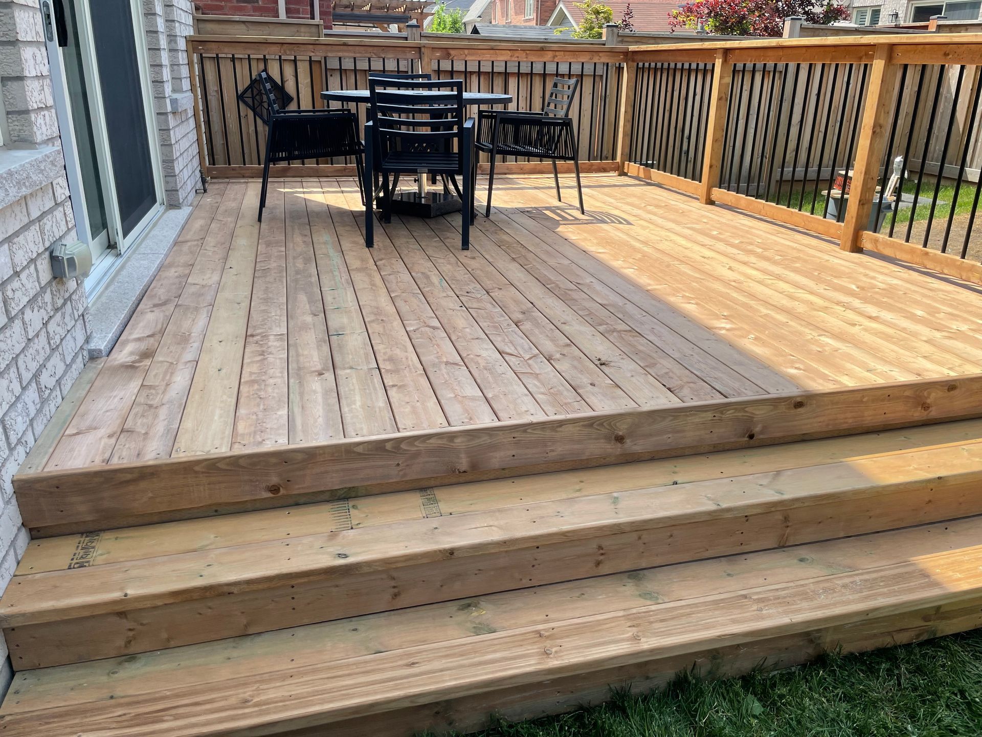 A wooden deck with a table and chairs on it.
