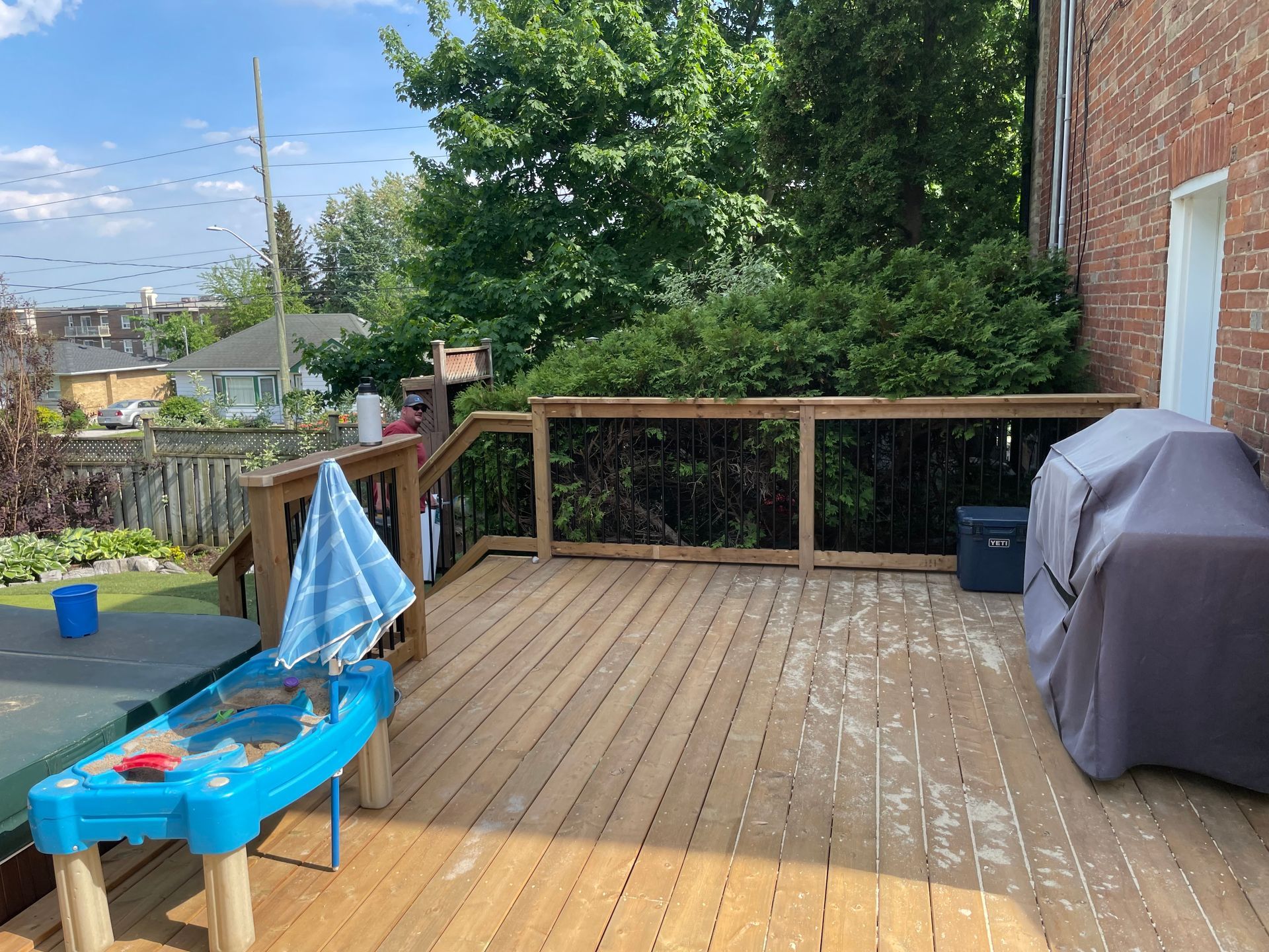 A wooden deck with a table and umbrella on it