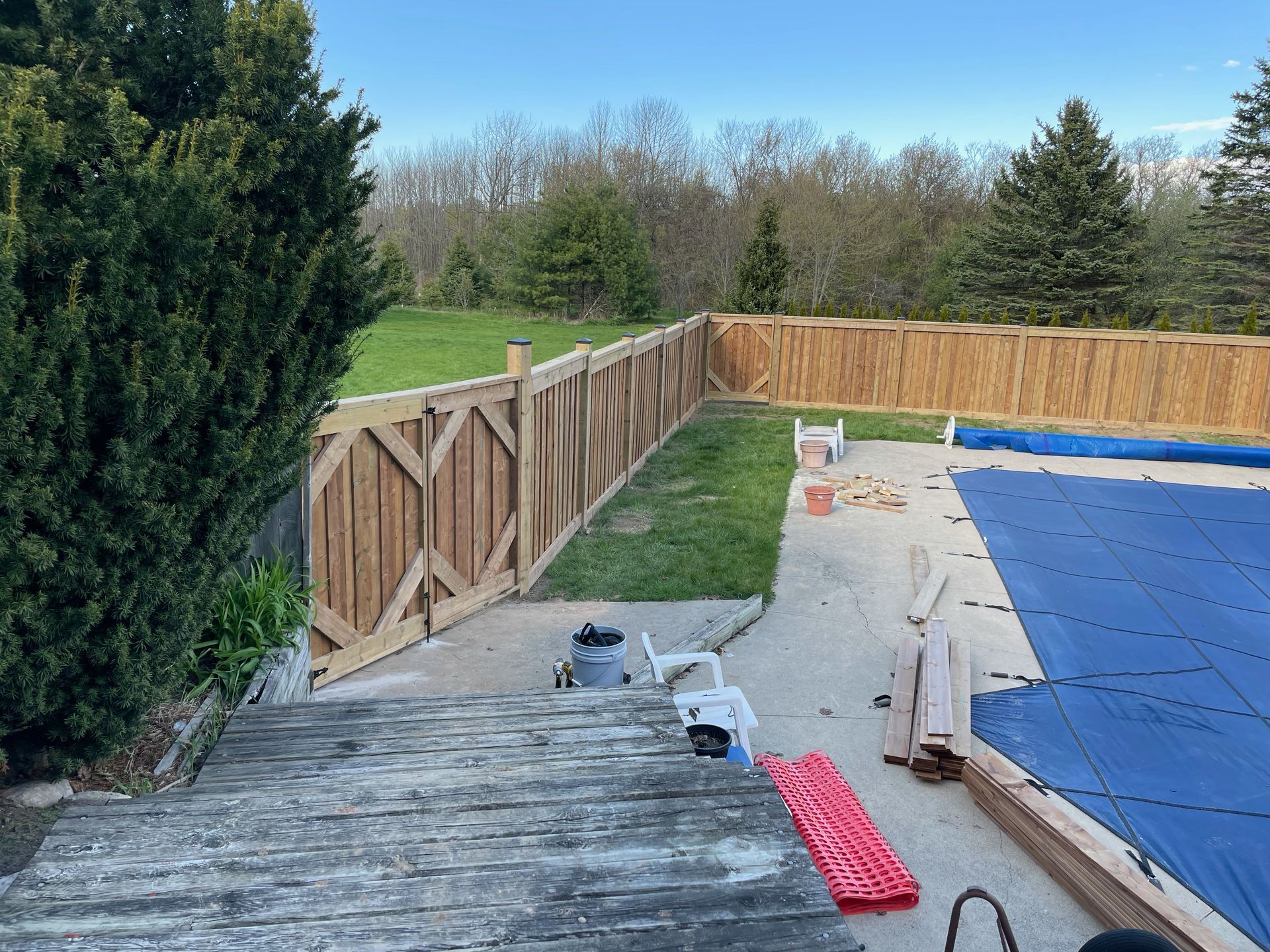 A wooden fence is being built around a swimming pool.