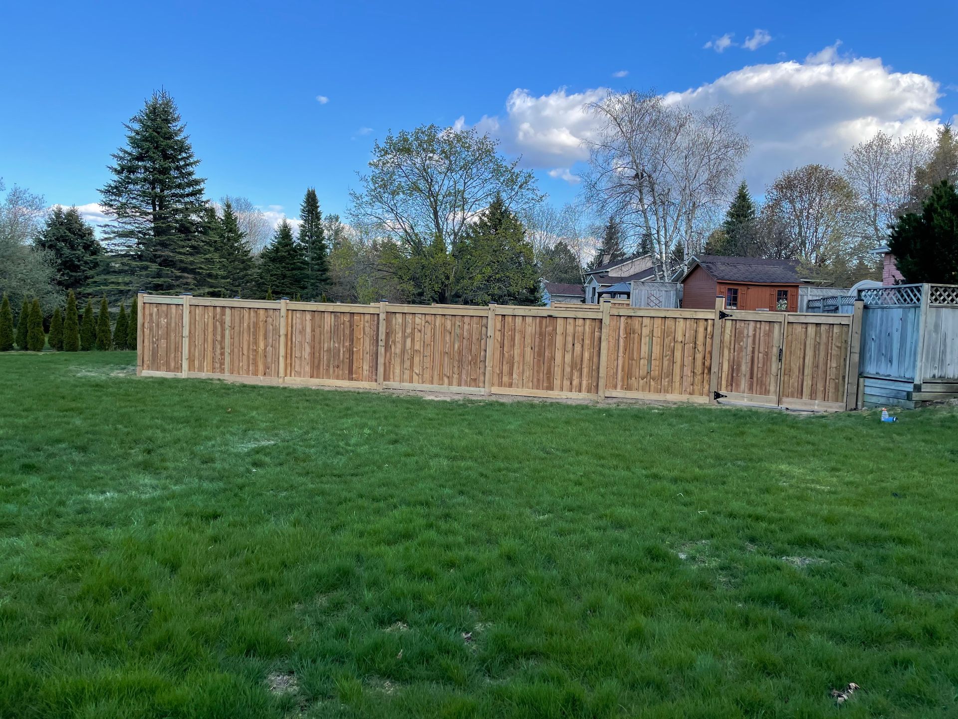 A wooden fence is sitting in the middle of a lush green field.