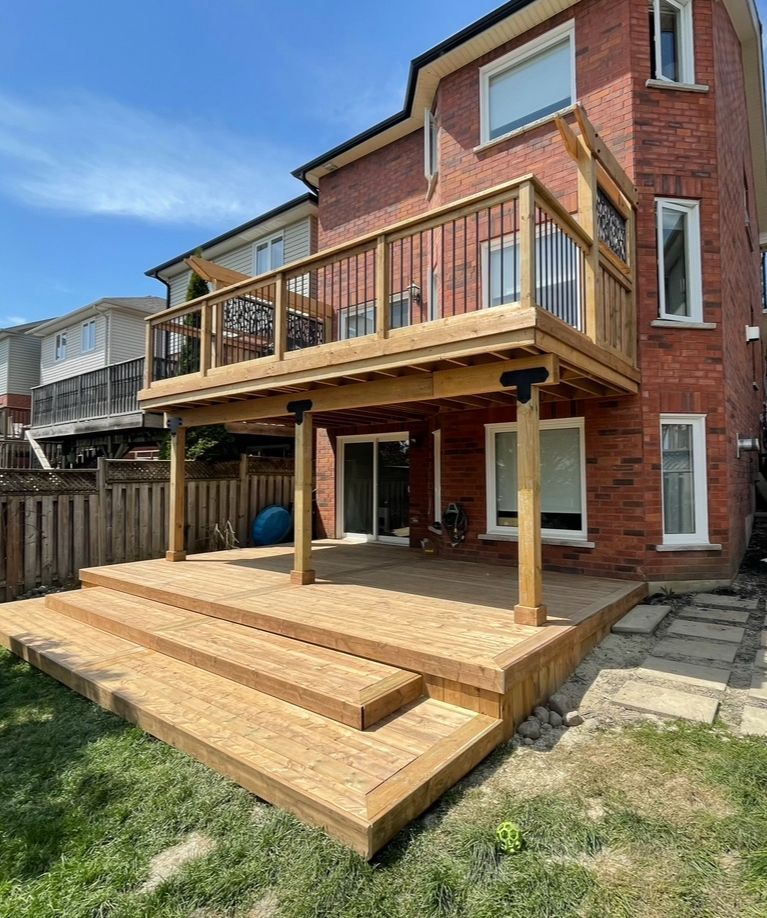A brick house with a wooden deck in front of it.