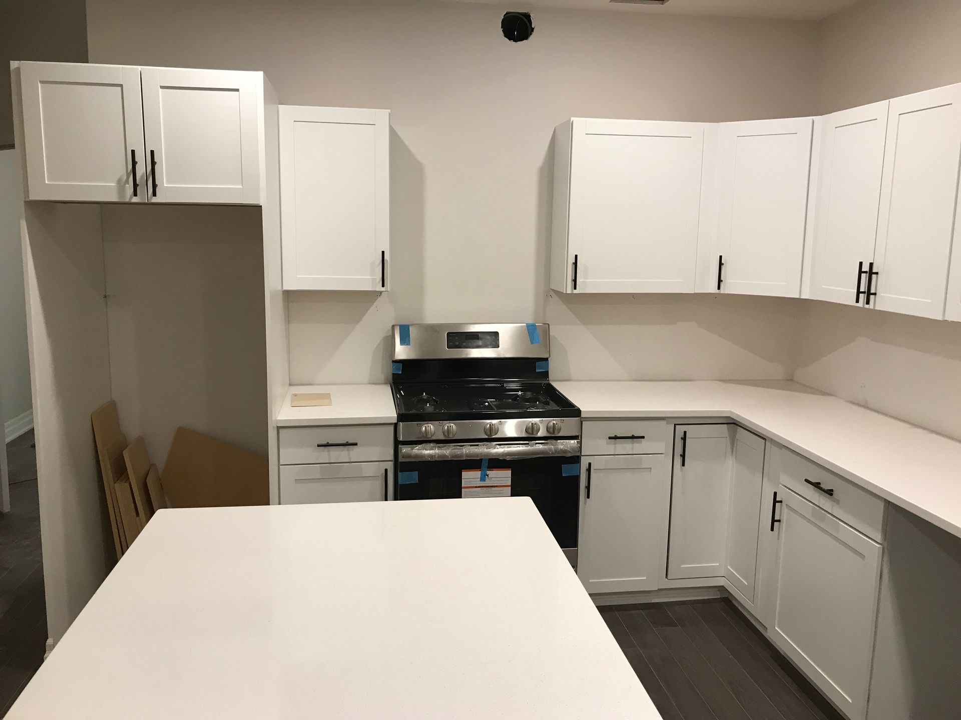 A kitchen with white cabinets and a stove top oven