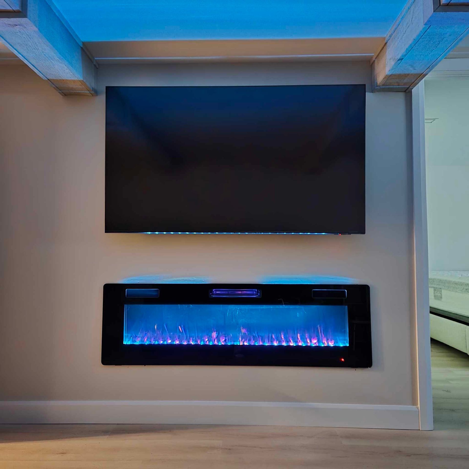A flat screen tv is mounted on a wall above a fireplace.