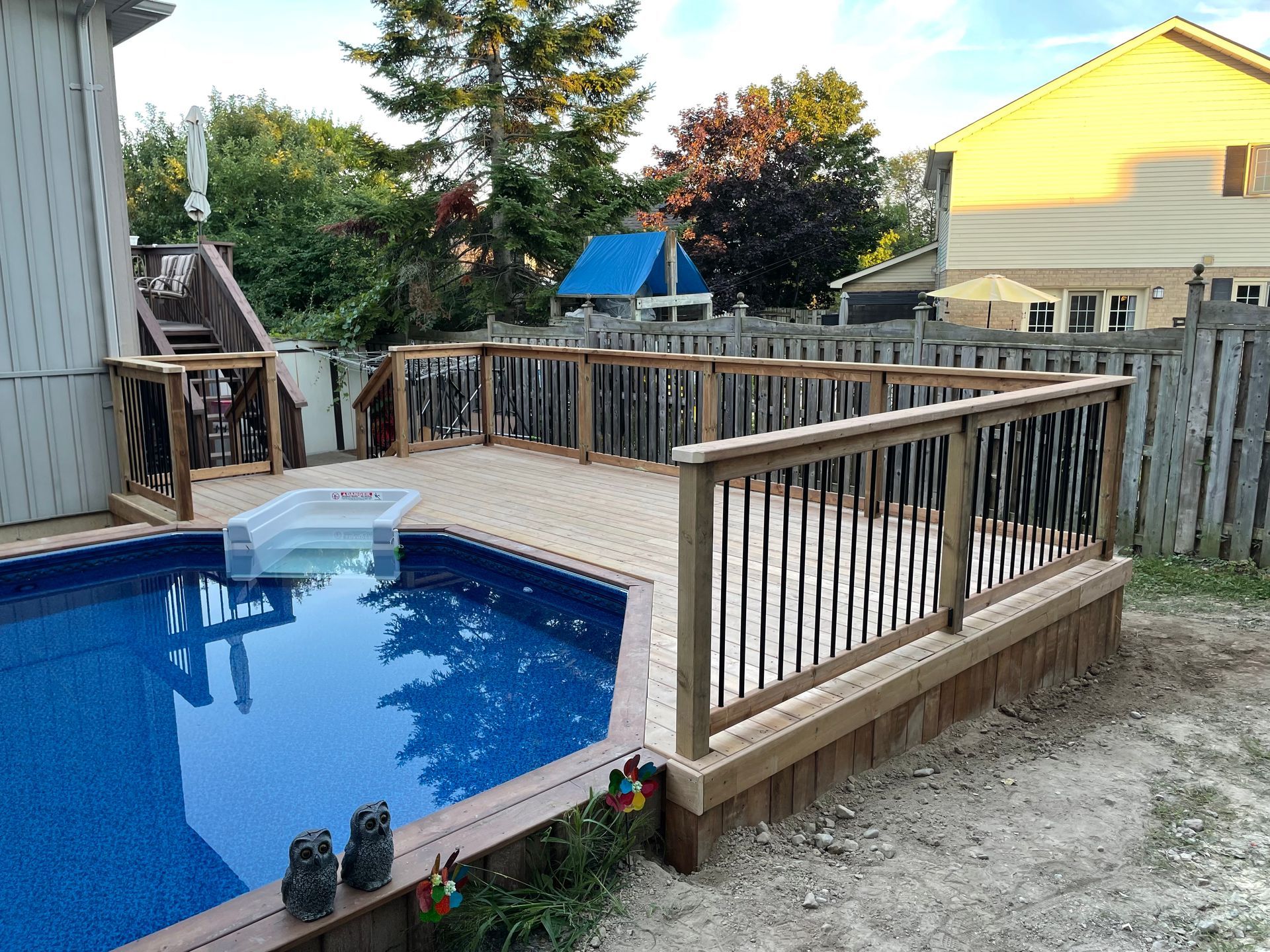 A swimming pool with a wooden deck surrounding it