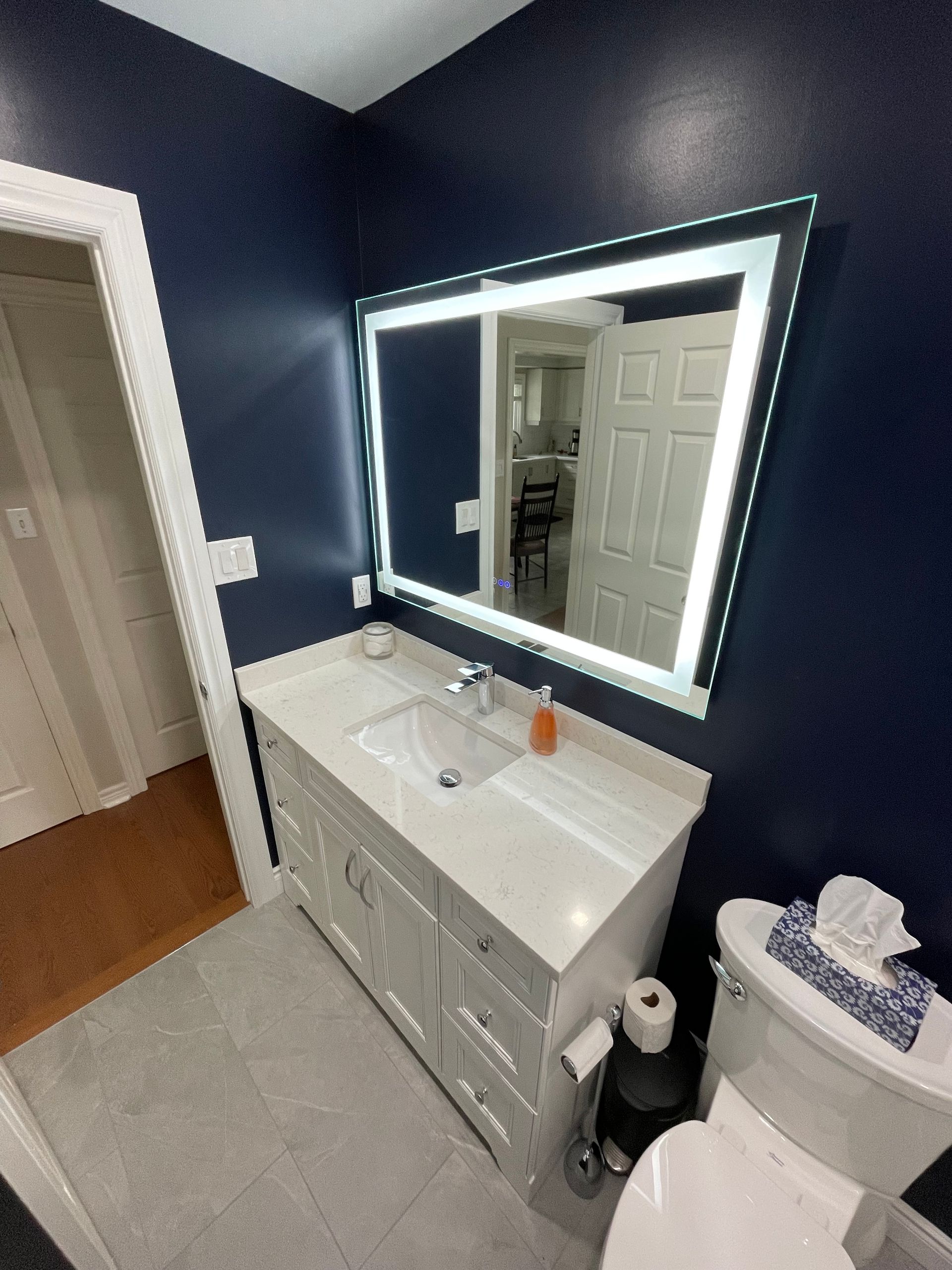 A bathroom with a sink , toilet and mirror.
