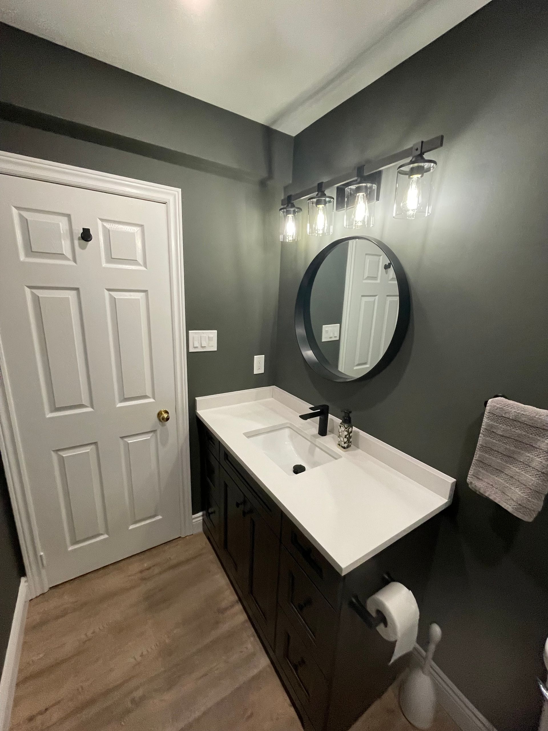 A bathroom with a sink , mirror and towel rack.