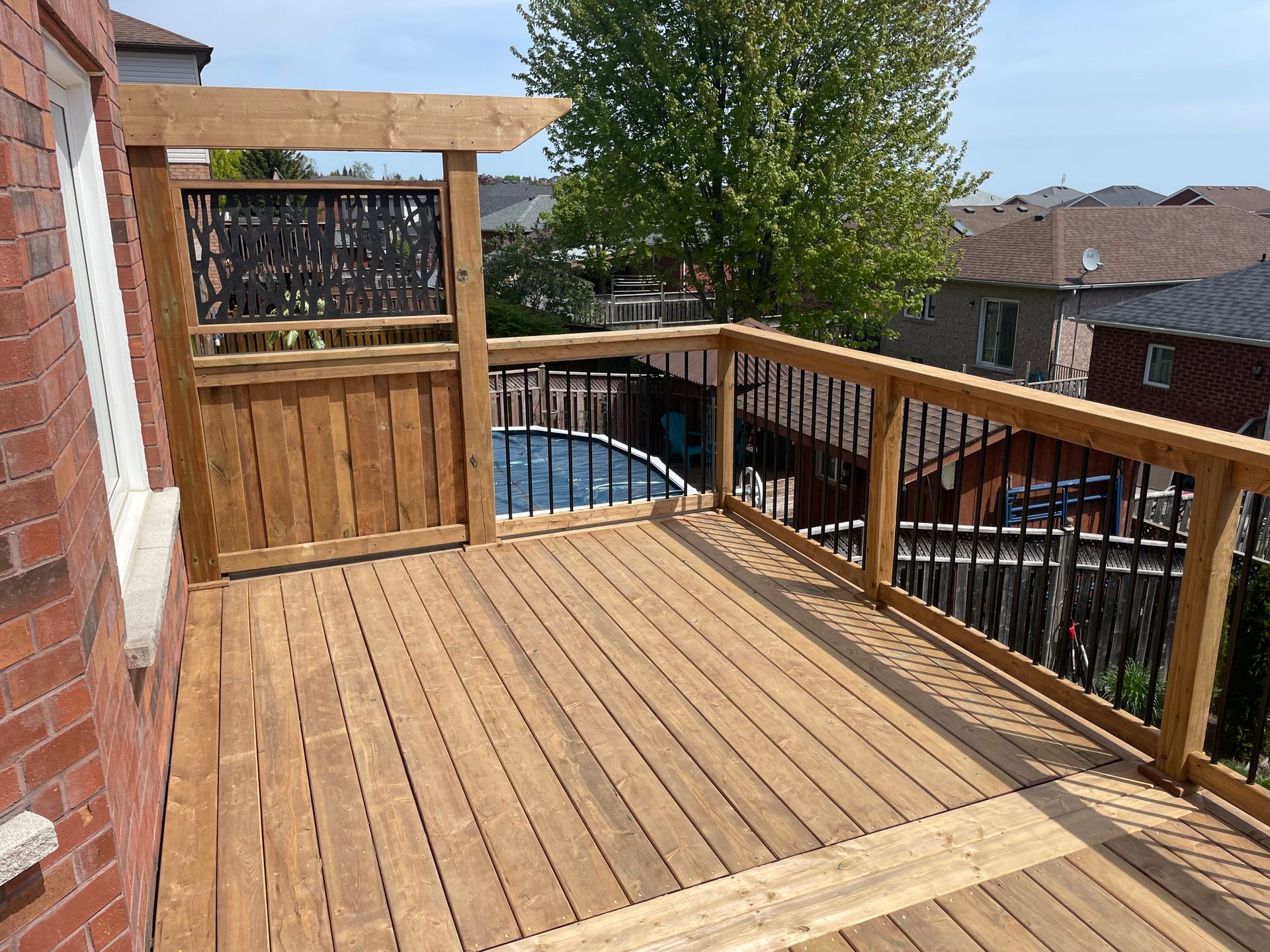 A wooden deck with a pool in the background