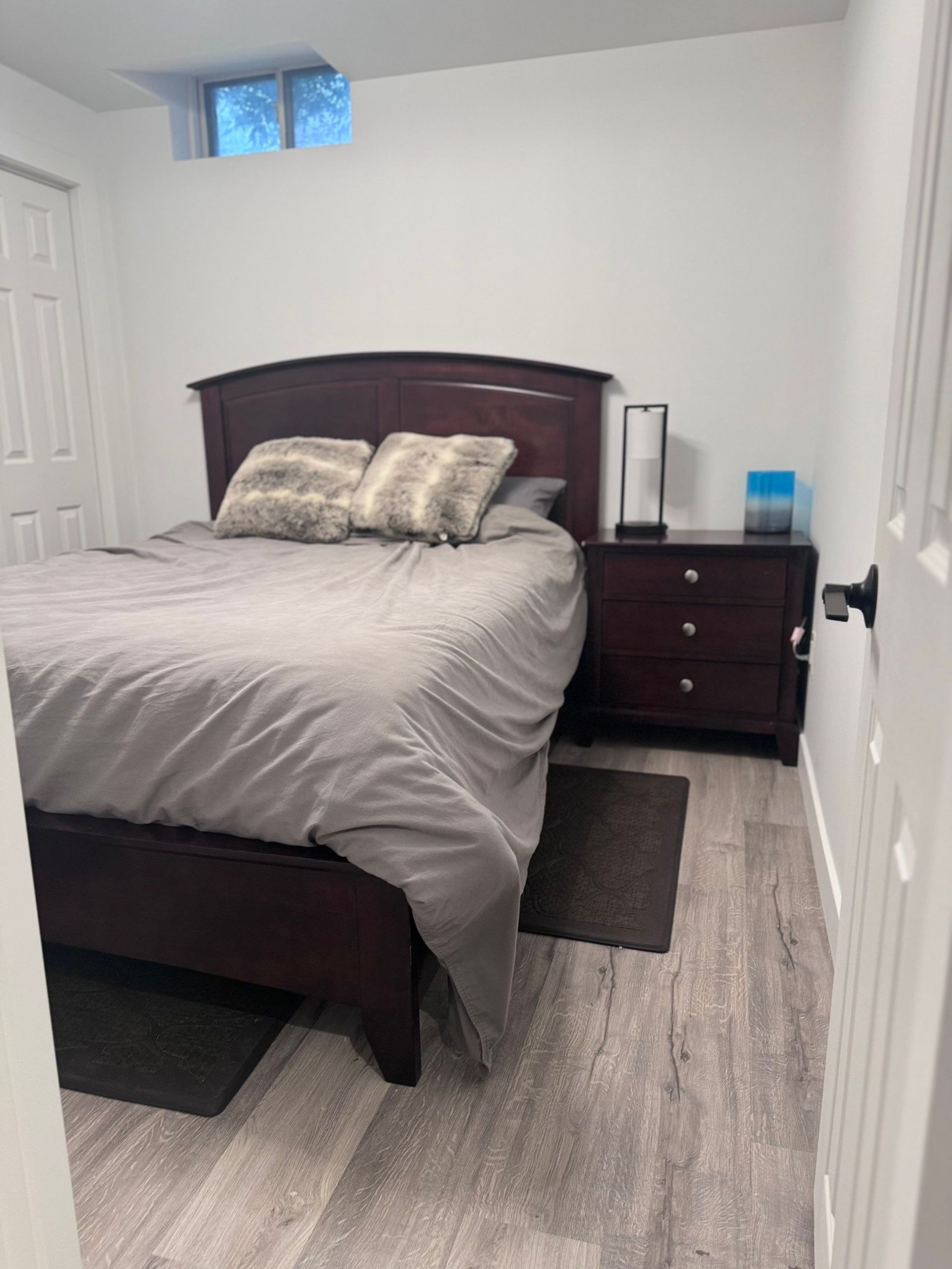 A bedroom with a bed , nightstand and window