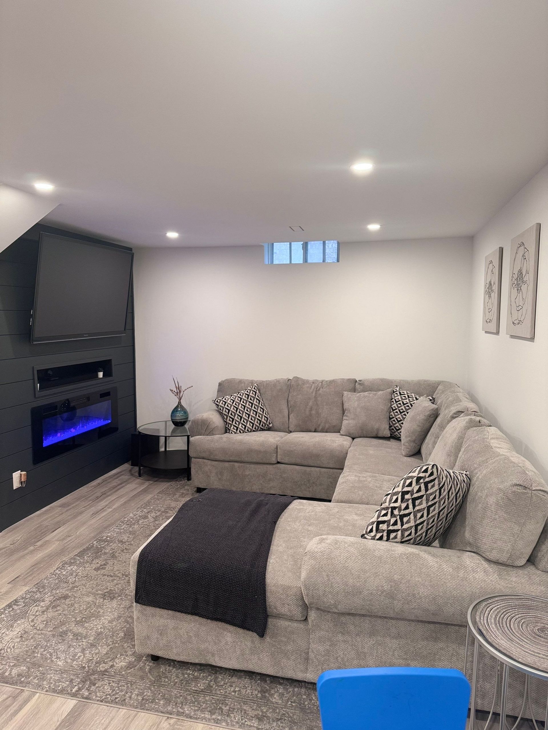 A living room with a sectional couch and a fireplace.