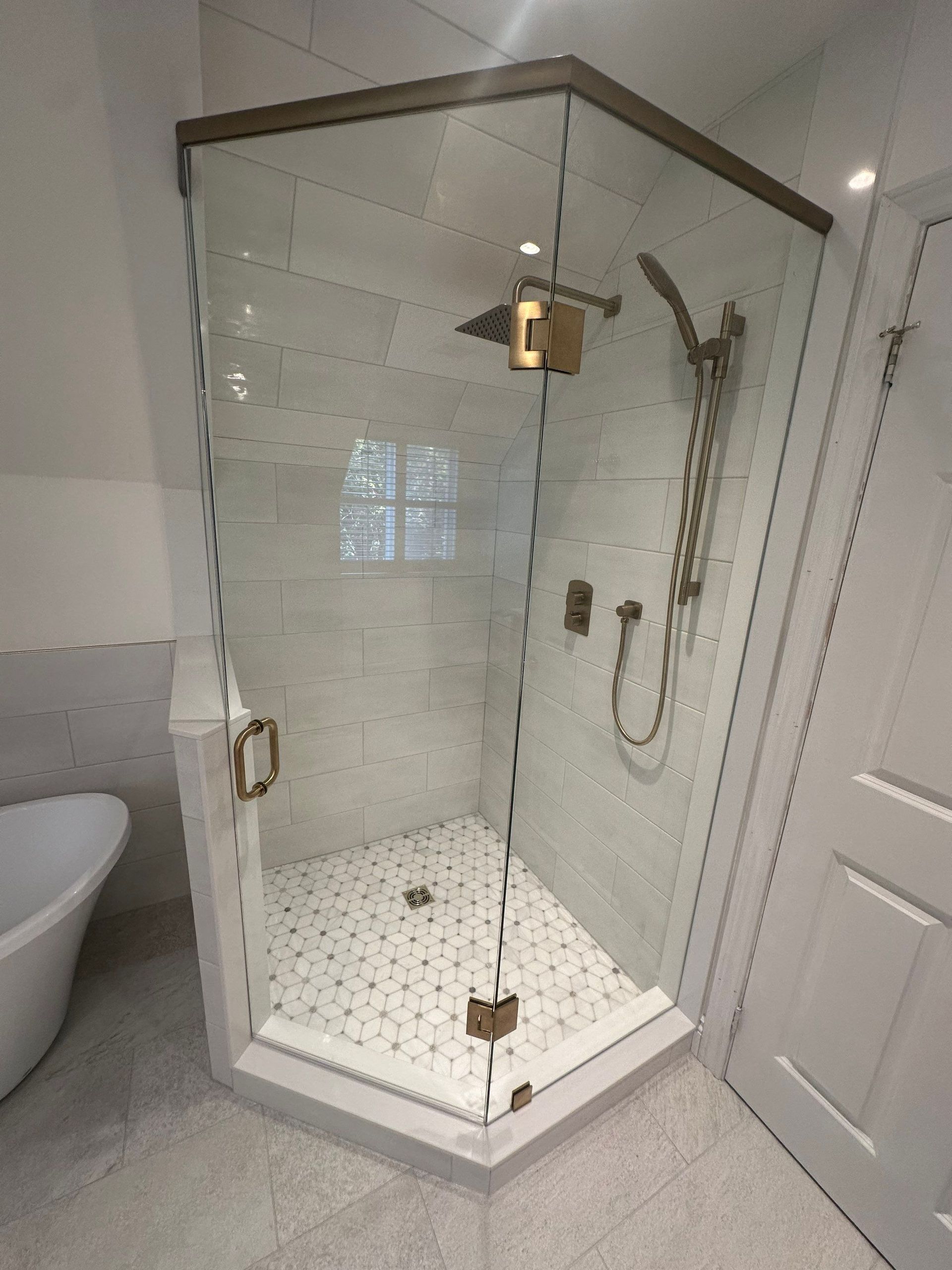 A bathroom with a shower stall and a tub