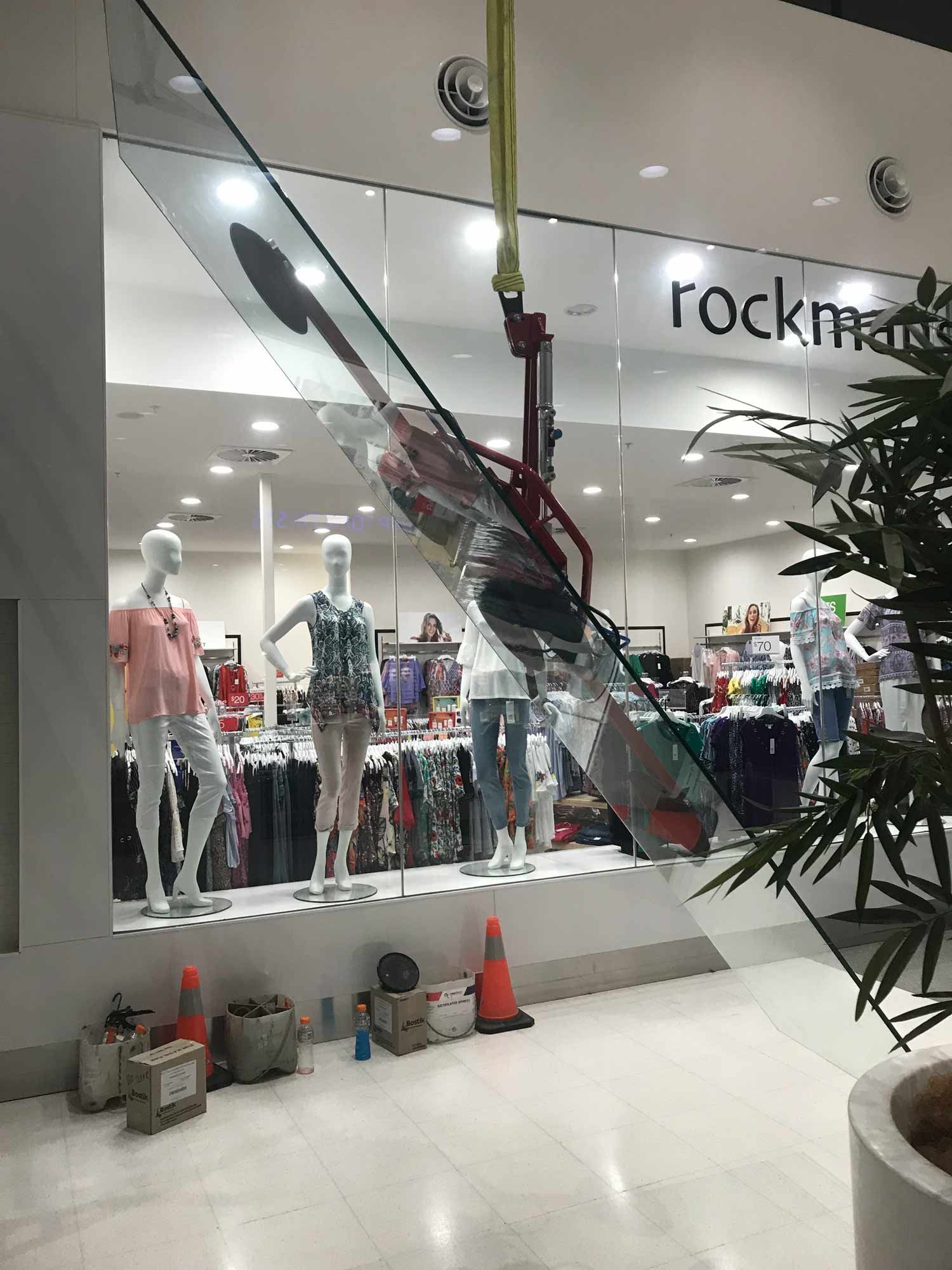 A Small Crane Used for Installing Glass Wall in Mall — Glass Windows & Doors in Shoalhaven, NSW