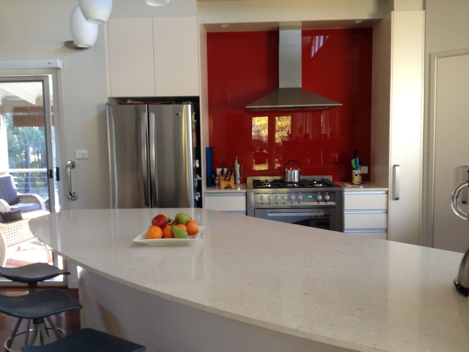 A Kitchen with a Red Wall Splashback behind the Exhaust — Glass Windows & Doors in Shoalhaven, NSW