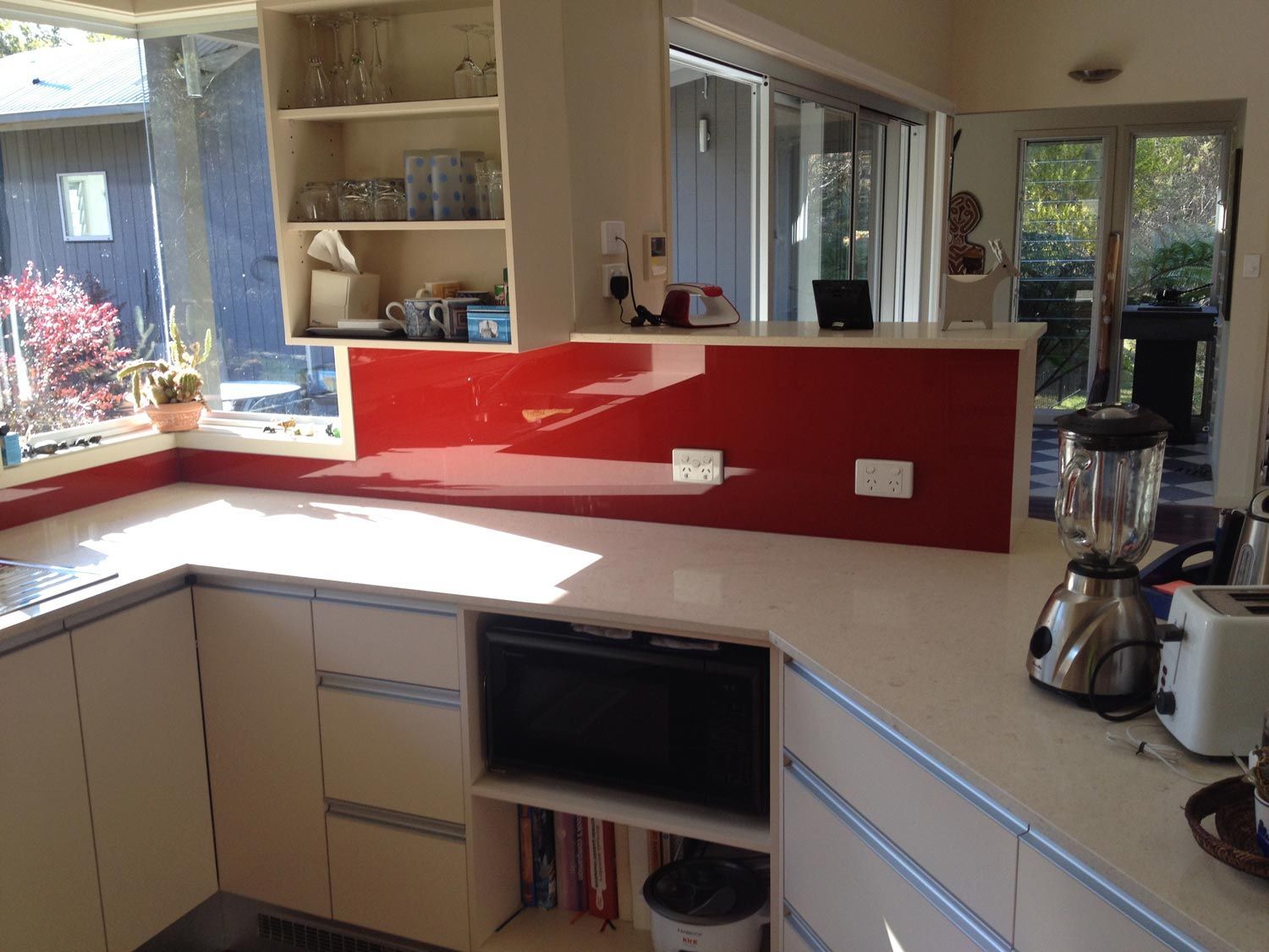 A Kitchen with a Red Wall Splashback — Glass Windows & Doors in Shoalhaven, NSW