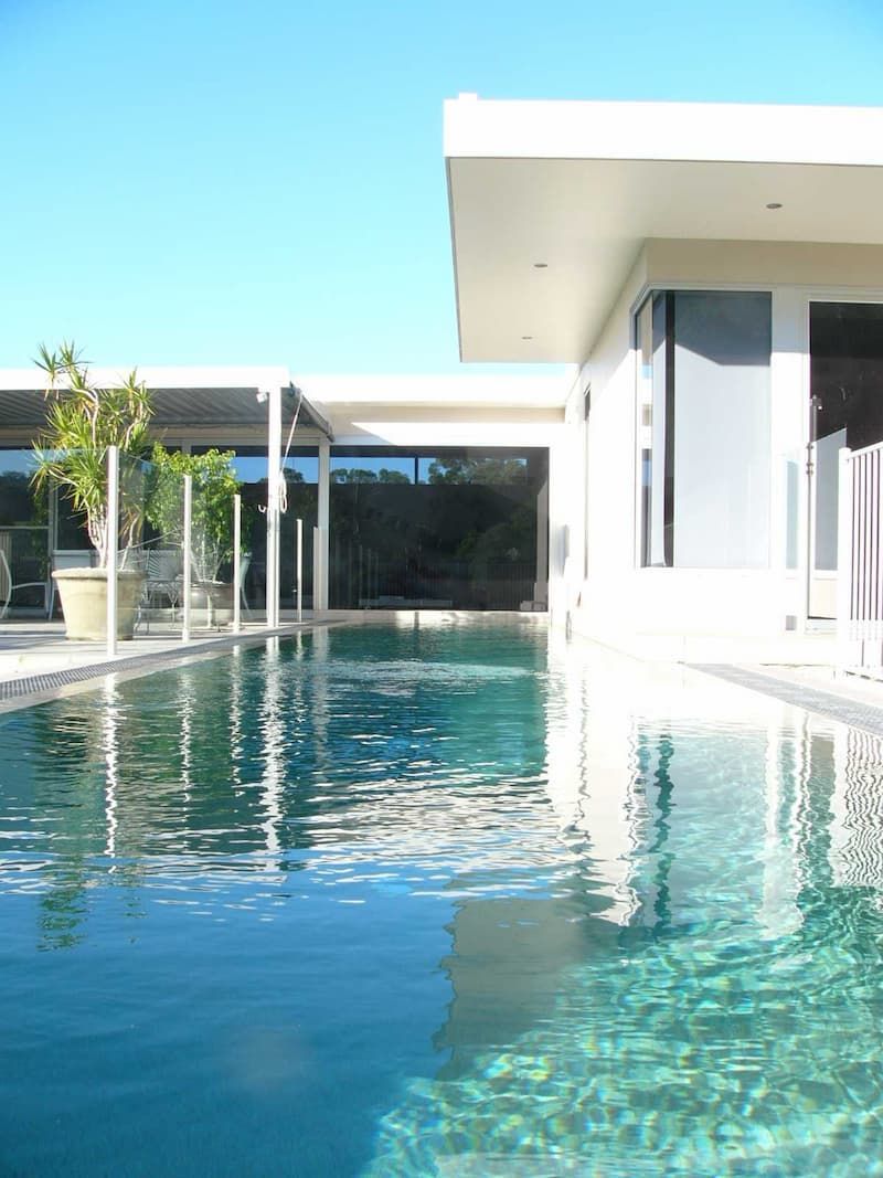 A Large Swimming Pool Next To A White Building - Previous Projects in South Nowra, NSW
