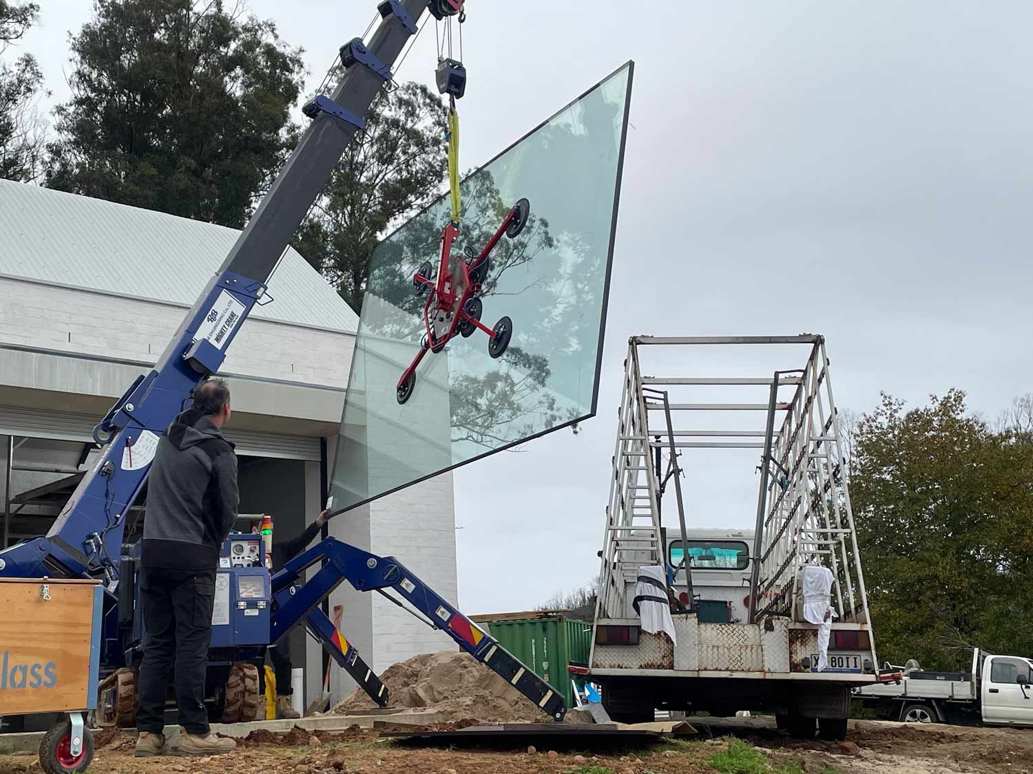 A Truck Holding Large Piece Glass — Glass Windows & Doors in Shoalhaven, NSW