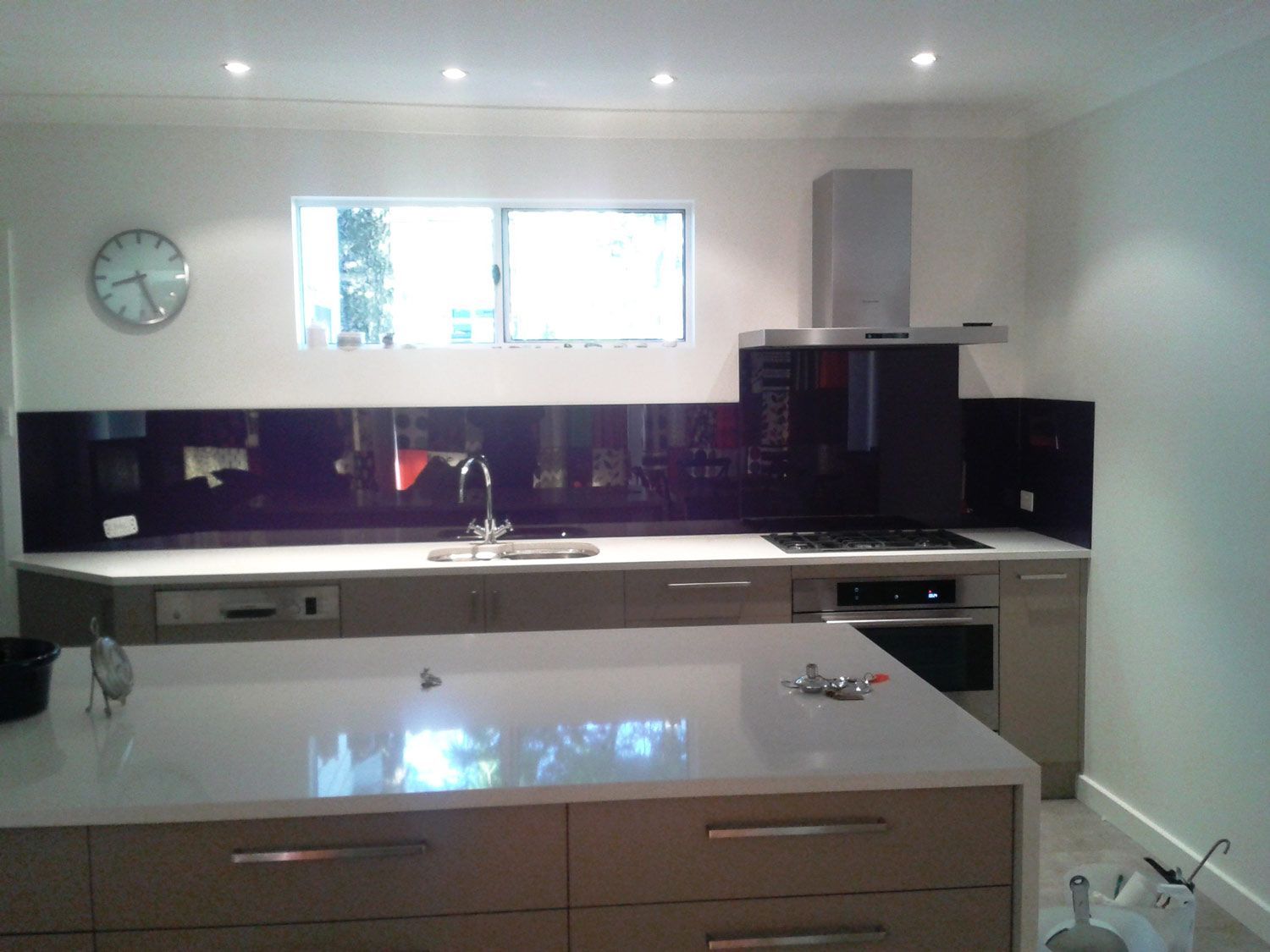 A Kitchen with a Violet Wall Splashback  and Center Table — Glass Windows & Doors in Shoalhaven, NSW